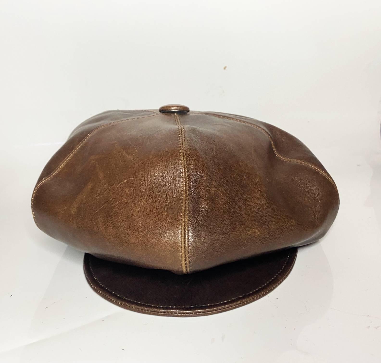Christian Dior flap cap, brown leather, newsboy cap design, brass button detail on side, black logo lining, Made in France 

Condition: 2000s, very good, minimal sign of wear, barely visible
Size: M
Measurements:
Outside diameter: 28cm 