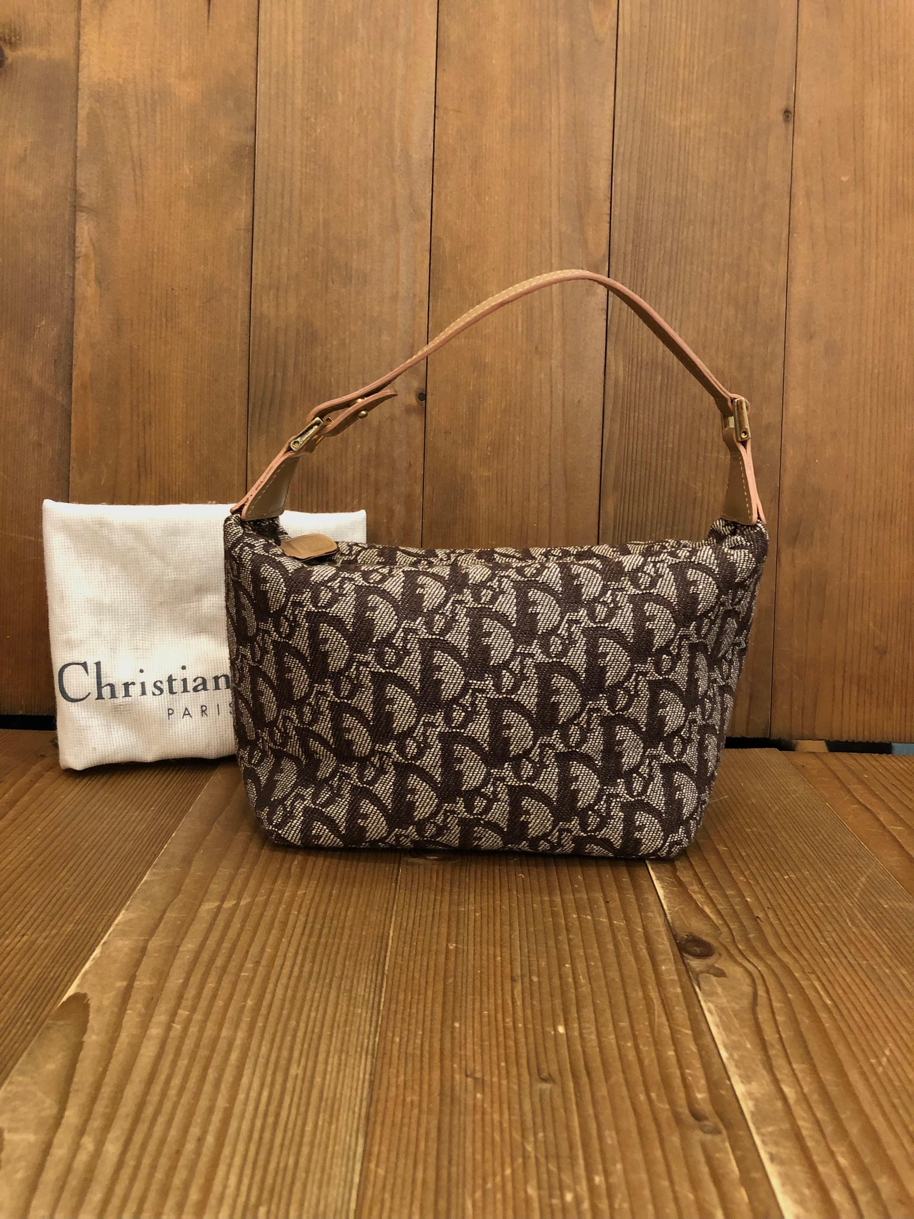 This vintage Christian Dior pouch handbag is crafted of Dior’s iconic trotter jacquard in brown. Zipper top closure opens to a brown fabric interior with one zippered pocket. Made in Spain. Compact in size yet big enough for your cell phone and