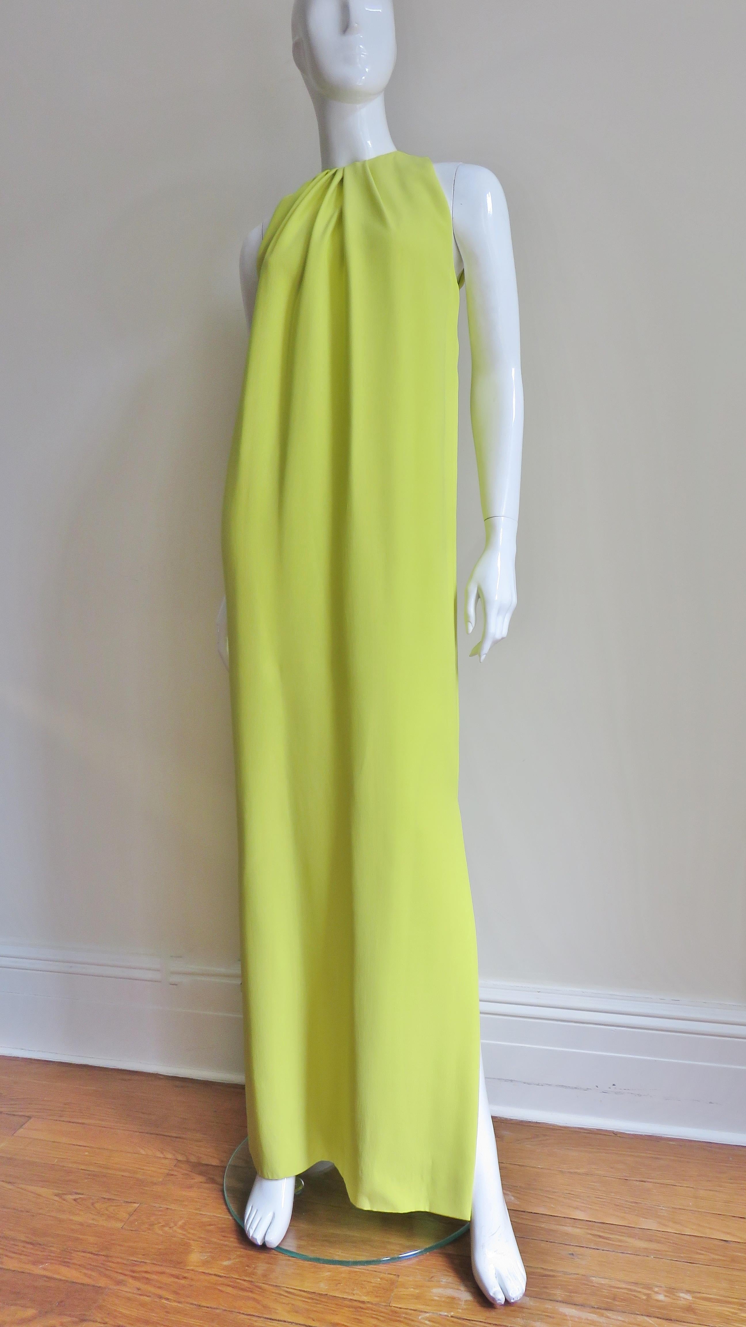 A beautiful yellow silk gown dress from Christian Dior.  It is sleeveless and has a crew neckline with tucks around it's circumference opening to the hem which has a side slit- chic and elegant. It is lined in matching silk and has a matching