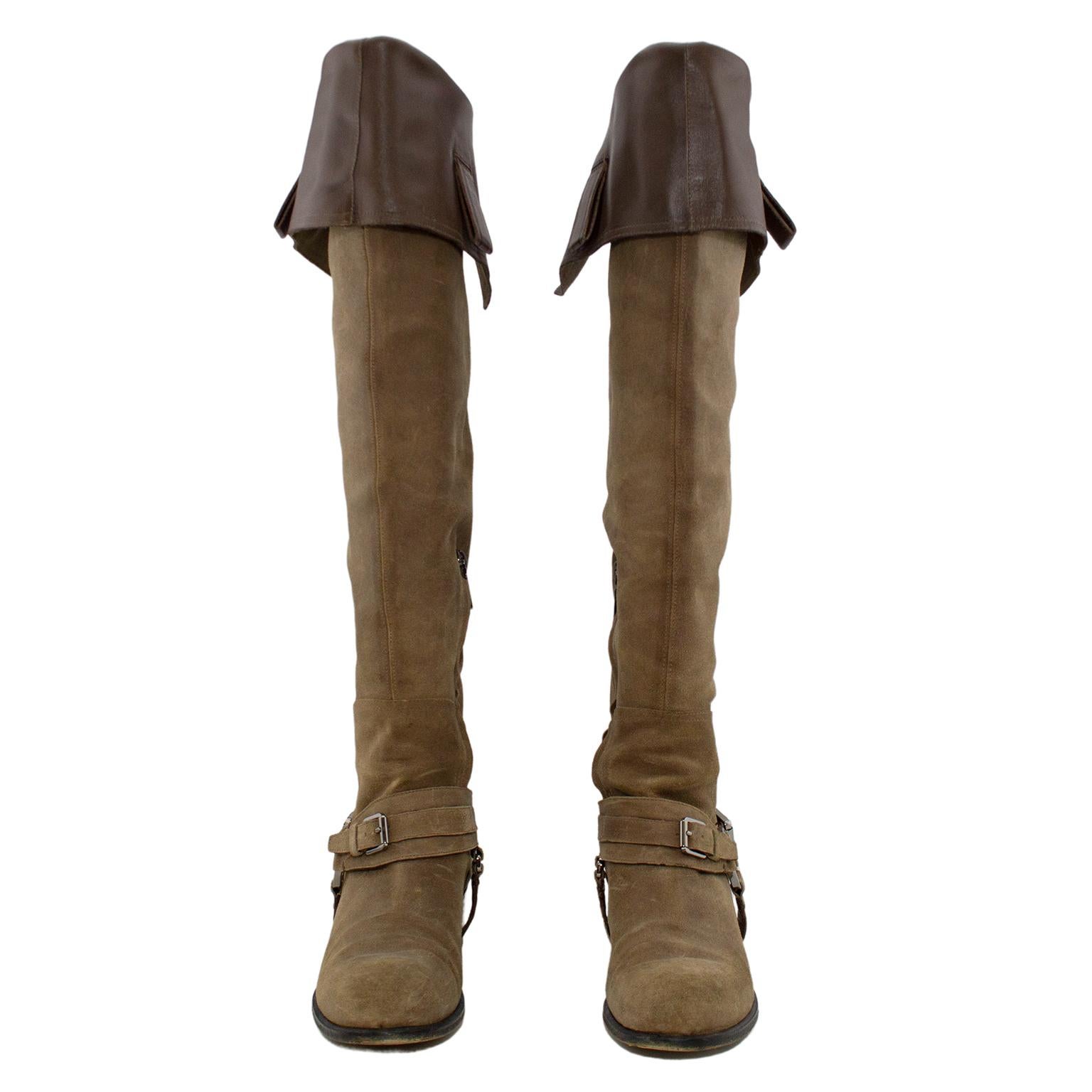 Chic taupe suede Dior over-the-knee buccaneer boots in excellent condition. Block heel on a heavy sole, wrap around straps and concealed inside zip closure, silver metal tone buckle and circular CD branded link. Heel 1.5