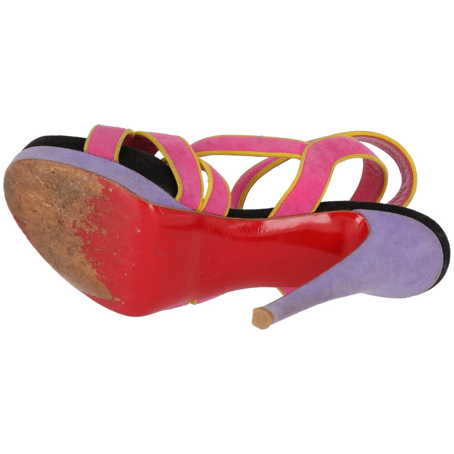 
The stylish Christian Louboutin fuchsia black and liliac suede and leather sandals feature a vertiginous 14 cm high stiletto heel, 3cm short plateau, and ankle buckle string fastening. 
The item shows some signs of wear on the soles, as shown in
