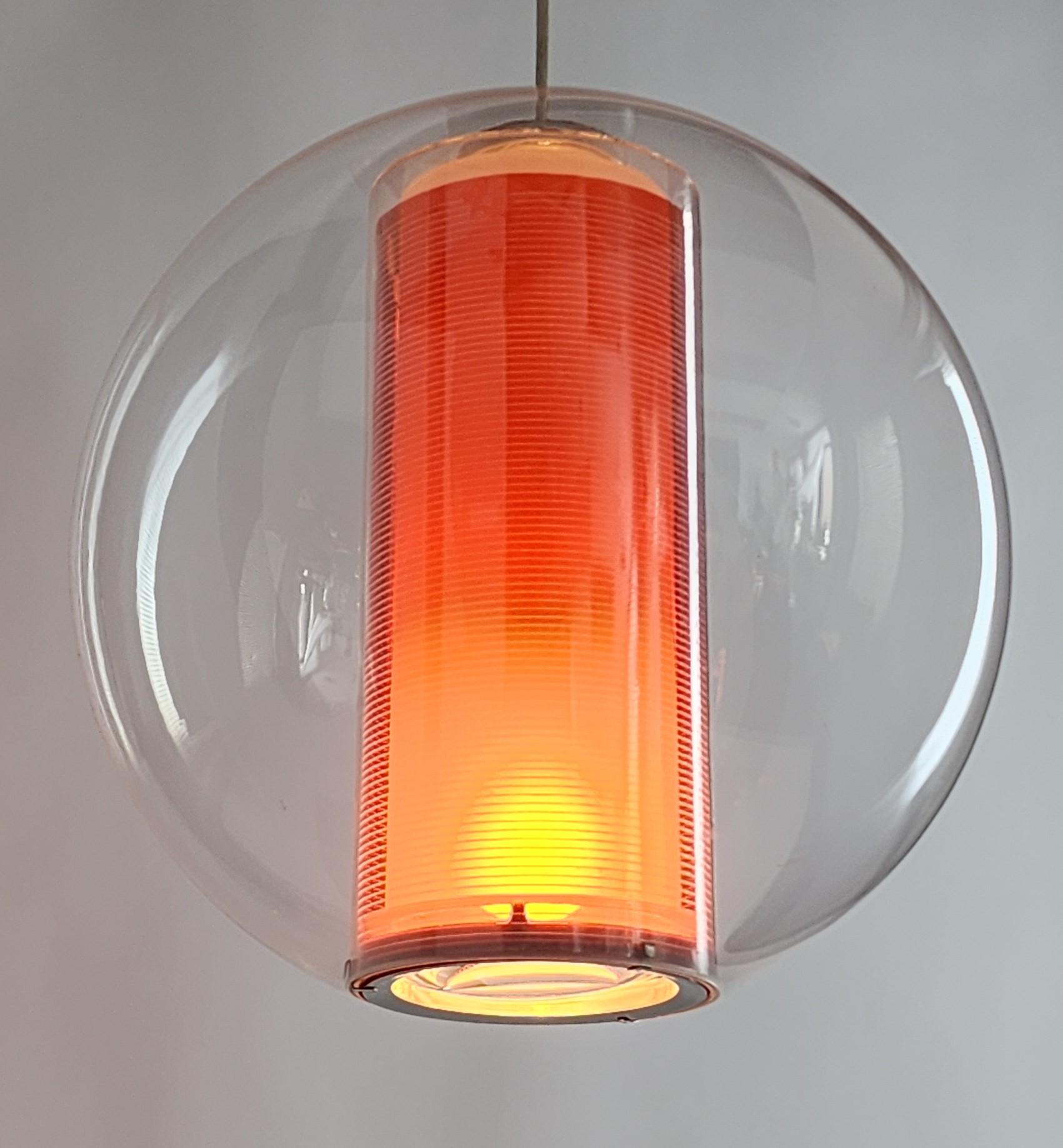 Large clear acrylic (not smoked) pendant with orange sleeve providing a warm glow. 

A convex glass diffuser narrows a ray of light under. 

Well-vented on top for heat dispersion. 

Well made with prime quality material and hardware. 

Come