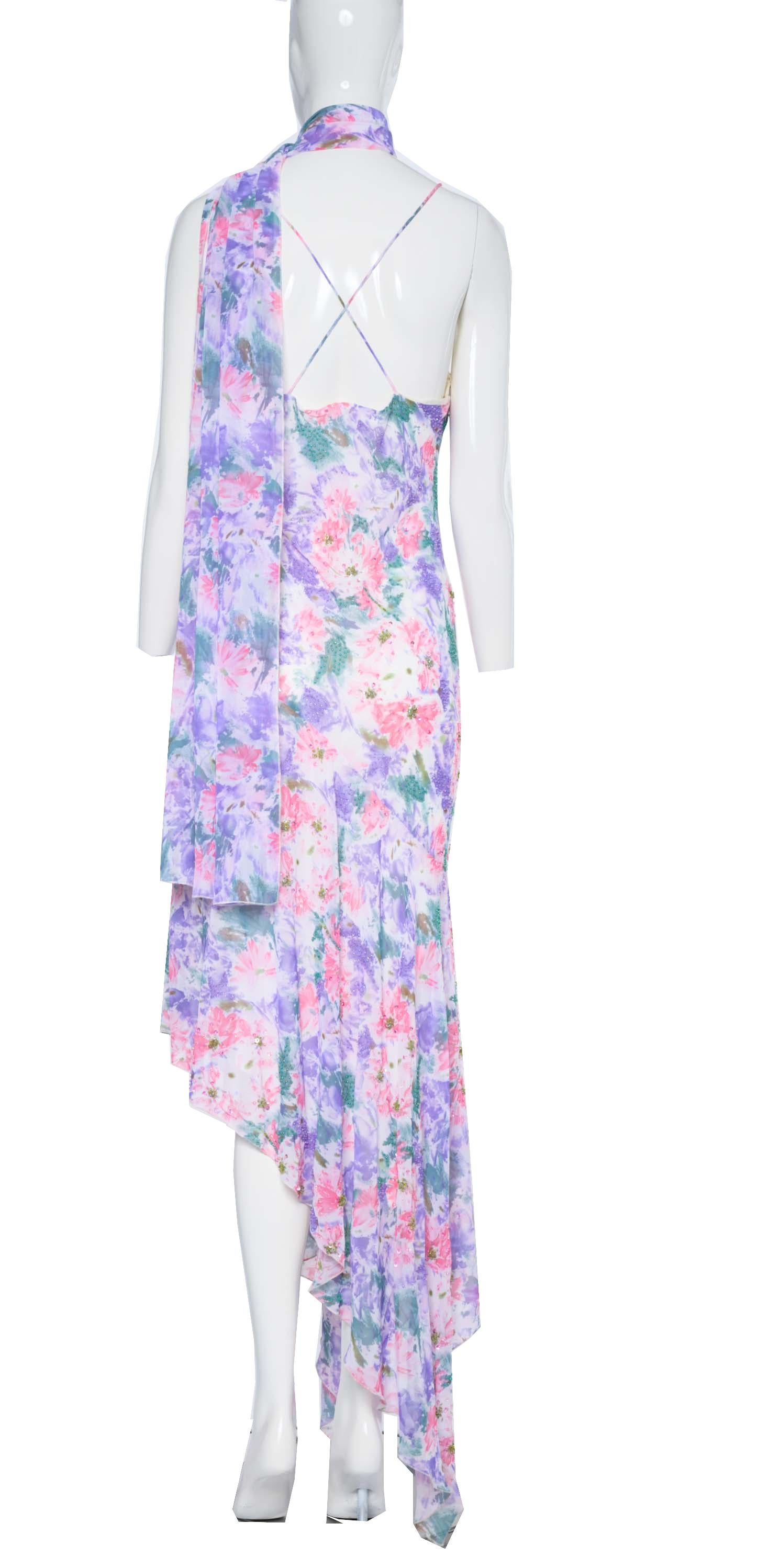 This vintage Diane Freis dress, with its beautiful purple and pink floral print on an ivory background, is perfect for a variety of occasions. Whether you are going to a garden party, a wedding, or a night out, this dress will make you feel like a