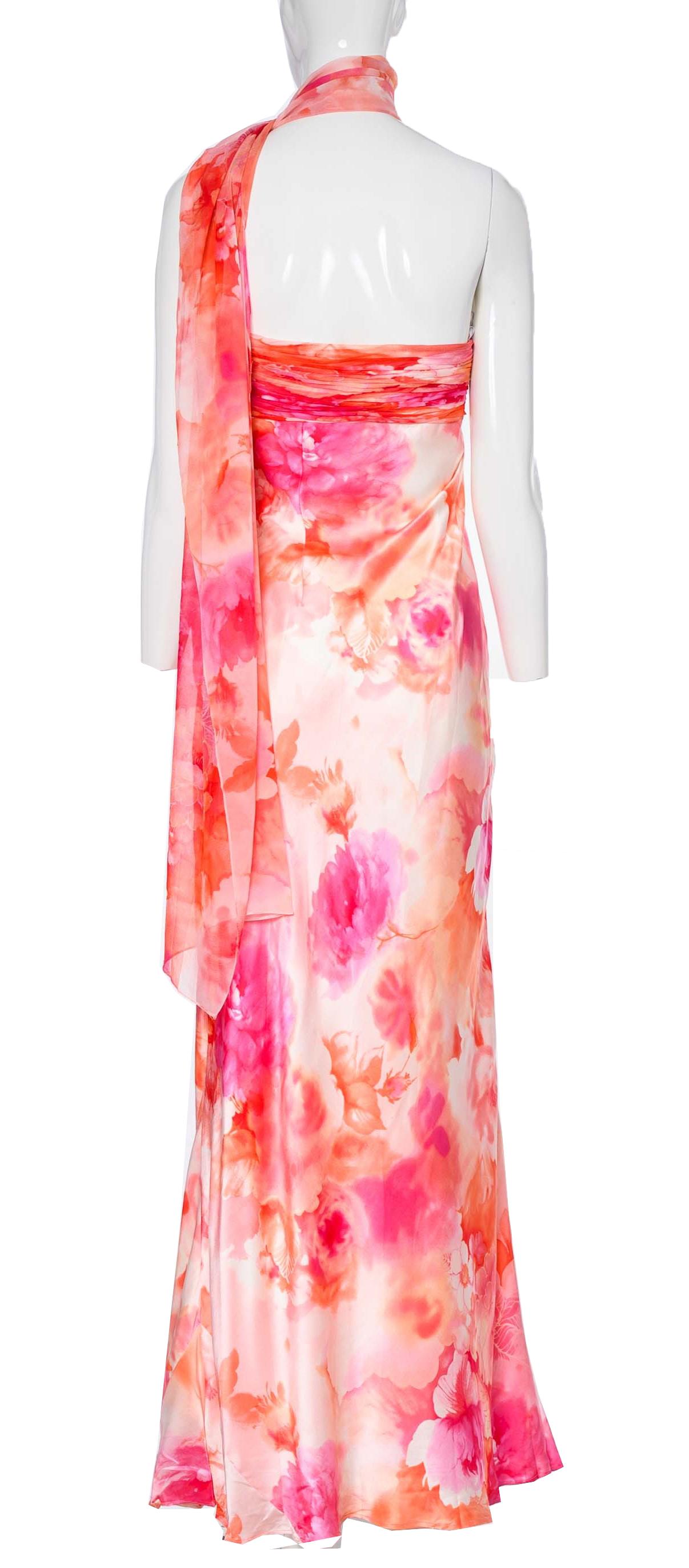 The Diane Freis Watercolour Floral Print Dress is a truly enchanting piece. Crafted from a vibrant silk fabric in a pink and red ombre design, this dress showcases a stunning and colorful display. The dress features intricate floral print details