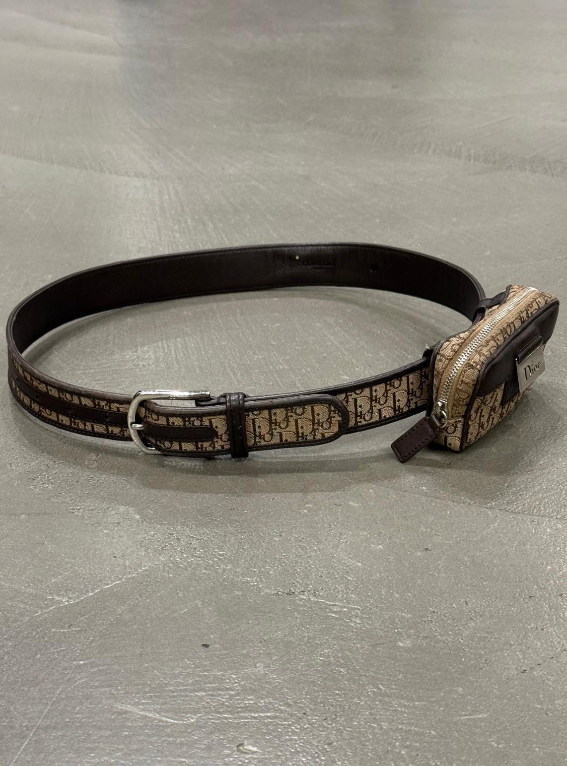 2000er Dior by Galliano Monogramm Gürteltasche

Dieser Dior-Gürtel aus den 2000er Jahren, der unter John Galliano entworfen wurde, zeigt das kultige Dior-Monogramm aus Canvas in Beige- und Brauntönen. Die kompakte Reißverschlusstasche ist mit einer
