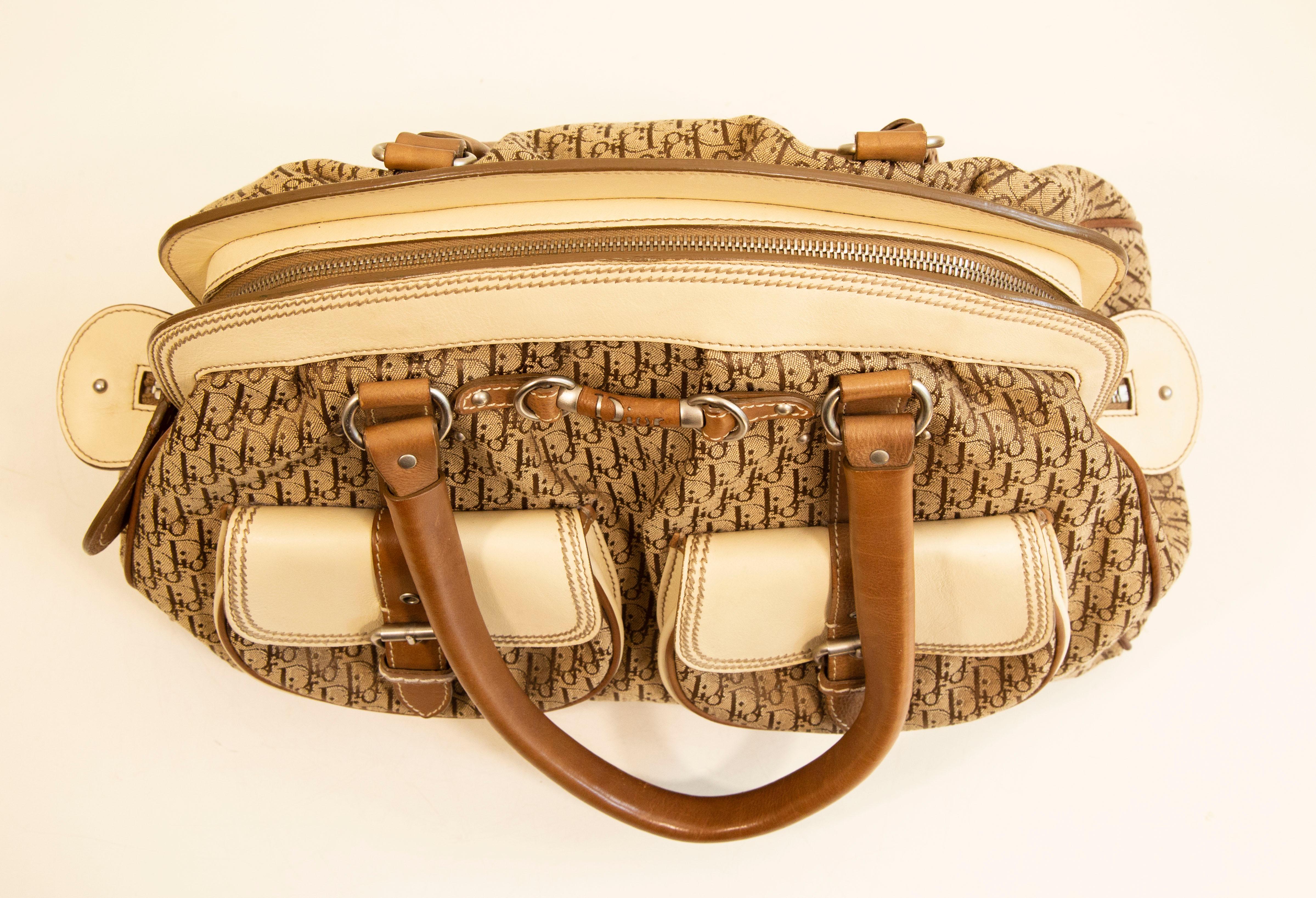 A vintage Dior Detective shoulder bag/frame satchel made of Dior logo beige canvas with beige and light brown leather trim. The interior is lined with synthetic beige fabric. Next to the major compartment, there are three side pockets of which one