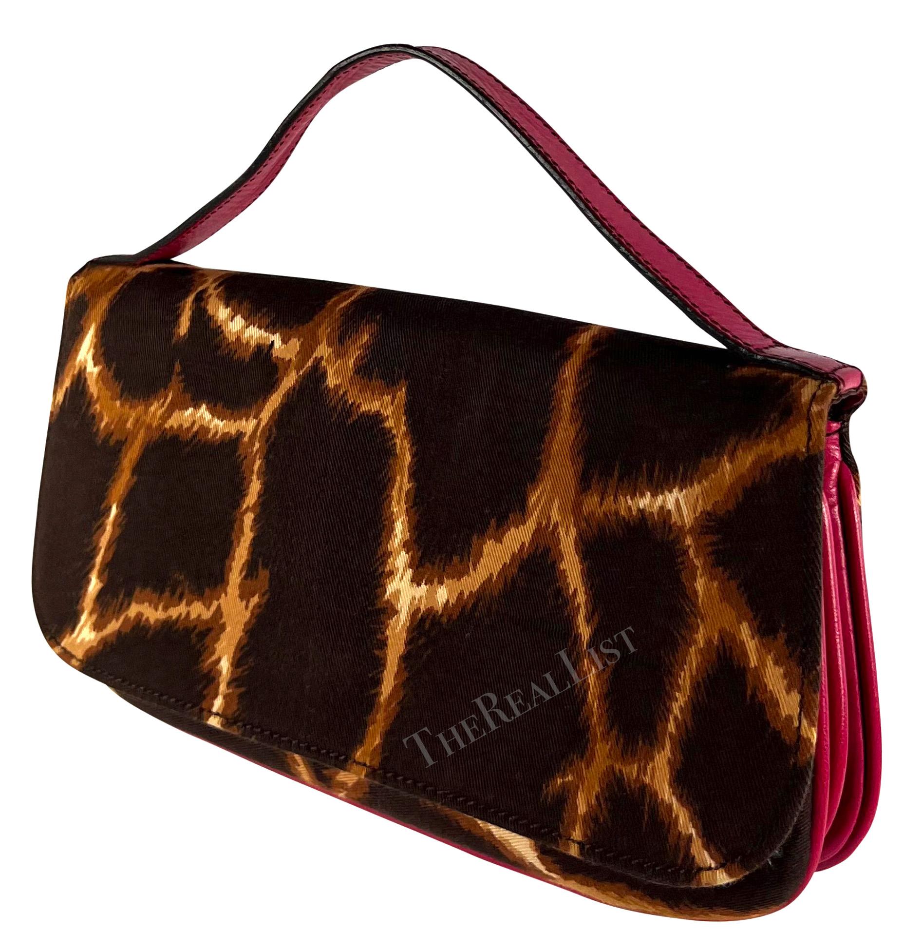 From the early 2000s, this fabulous giraffe print Dolce & Gabbana canvas clutch bag features a flap secured with a magnetic closure and is complete with a hot pink leather handle embossed with the brand's signature.

Approximate