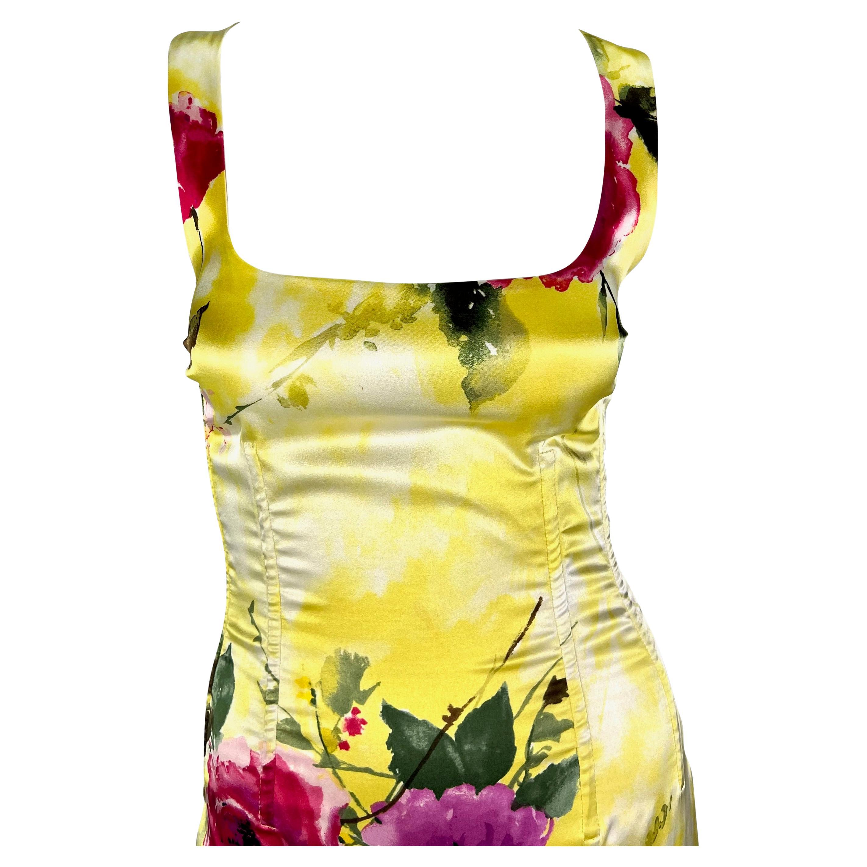 This stunning pastel yellow Dolce & Gabbana floral gown is covered in a beautiful pink floral print. This form-fitting satin dress features a square neckline, slit at the back and is made complete with corset boning.  The structured waist lends to a
