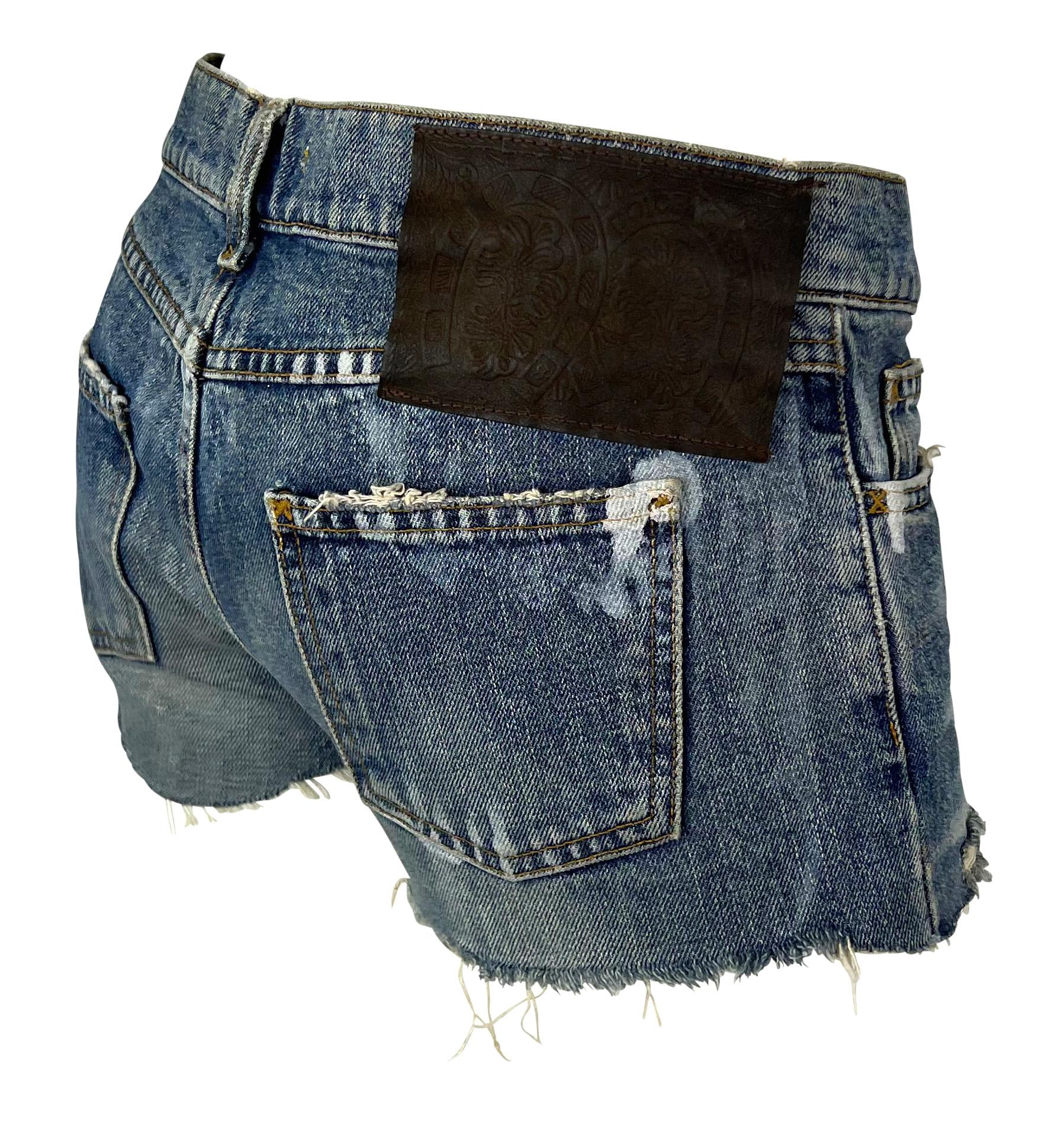 This pair of light wash Dolce & Gabbana mini shorts from the early 2000s is made of light wash denim and features intentional distressing, including rips, white paint marks, and various other distress marks throughout. The shorts are complete with a