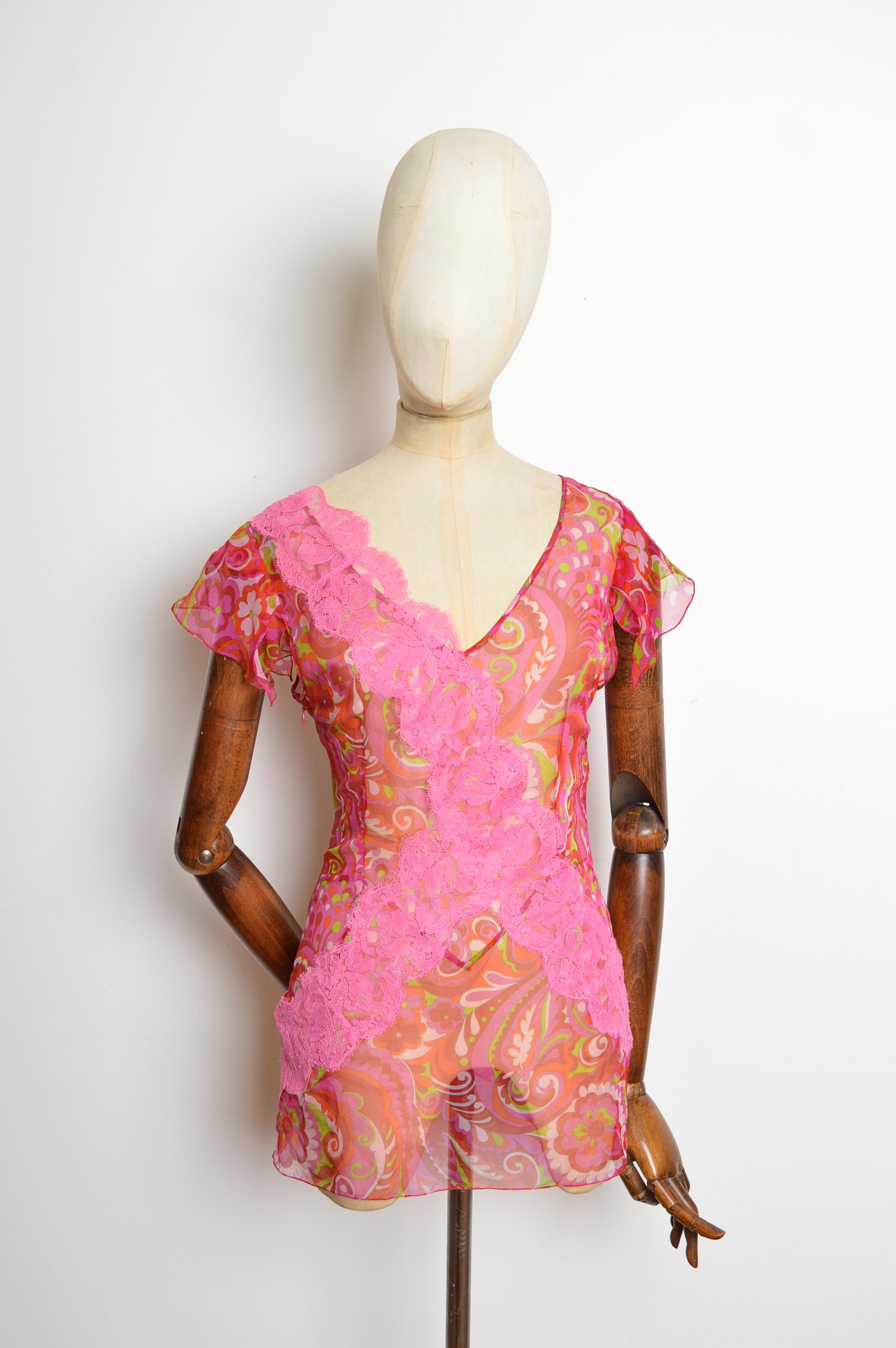 Eine großartige Bluse aus reiner Seide von Dolce & Gabbana aus den 2000er Jahren mit psychedelischen Einsätzen aus Chantilly-Spitze. Mit tiefem V-Ausschnitt, CAP-Ärmeln und hüftlangem Saum. 
Die Maße sind in Zoll ('') angegeben.
Empfohlene Größe; UK