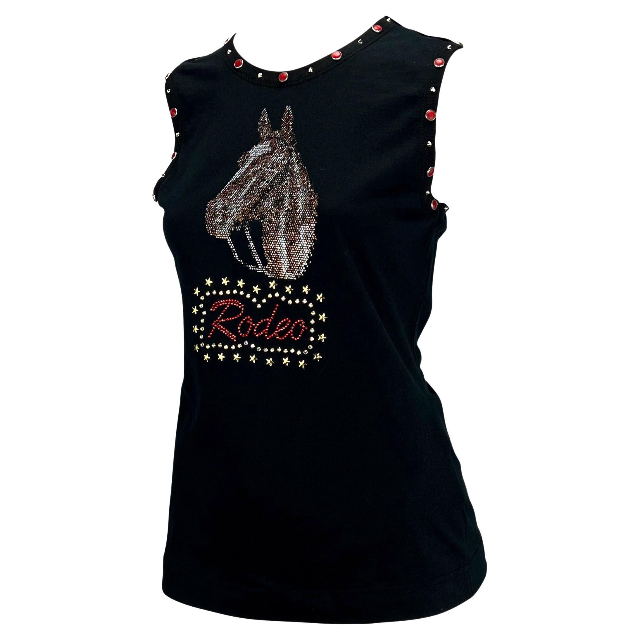 TheRealList presents: a fabulous western-inspired Dolce and Gabbana rhinestoned and studded sleeveless shirt. From the early 2000s, this black top with a horse head and 'Rodeo' created from multicolored rhinestones is peak Y2K style. The top is made