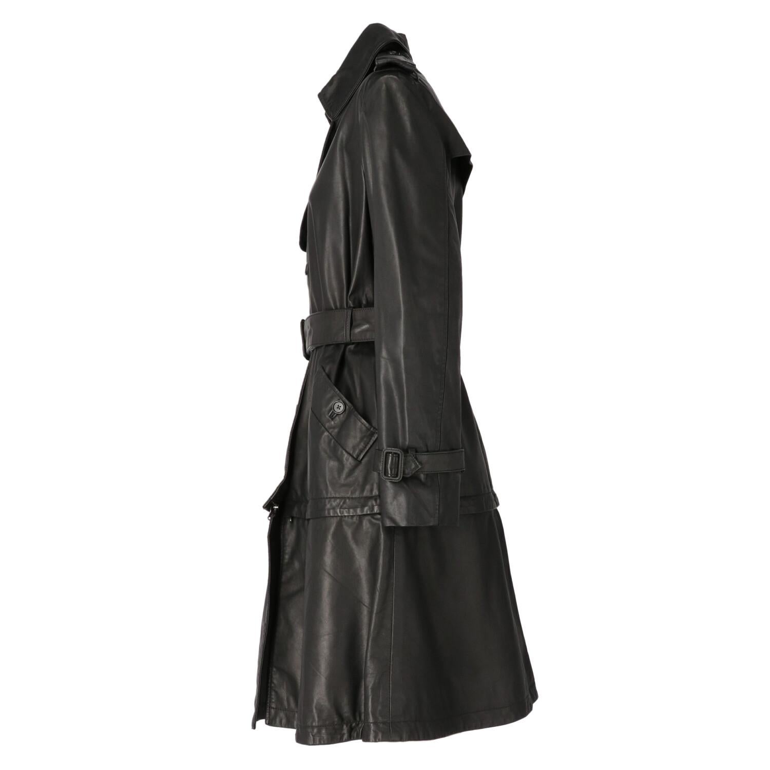 Emanuel Ungaro black leather trench coat. Classic collar, single-breasted closure with buttons and metal hooks. Windbreak flap, shoulder tabs with button, rain flap on the back. Long sleeves and cuffs with strap. Welt pockets and belt at the waist.