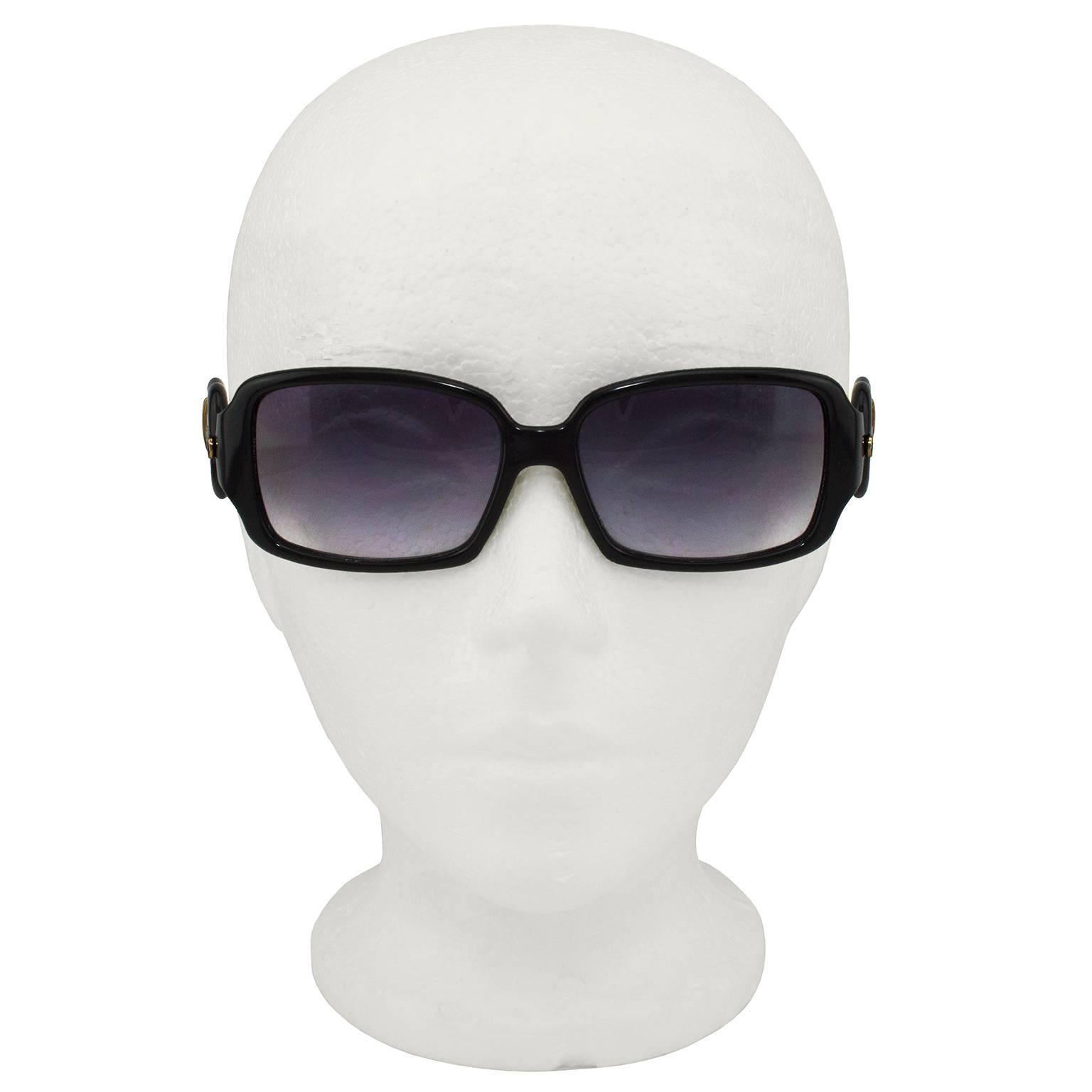 Fendi sunglasses from the 2000s. Black frames with cream arms and large buckle details and bronze hardware. Buckle details are iconic to Fendi and made famous by the B. Fendi bag. Faux stitching details on arms and brand/style info stamped in black