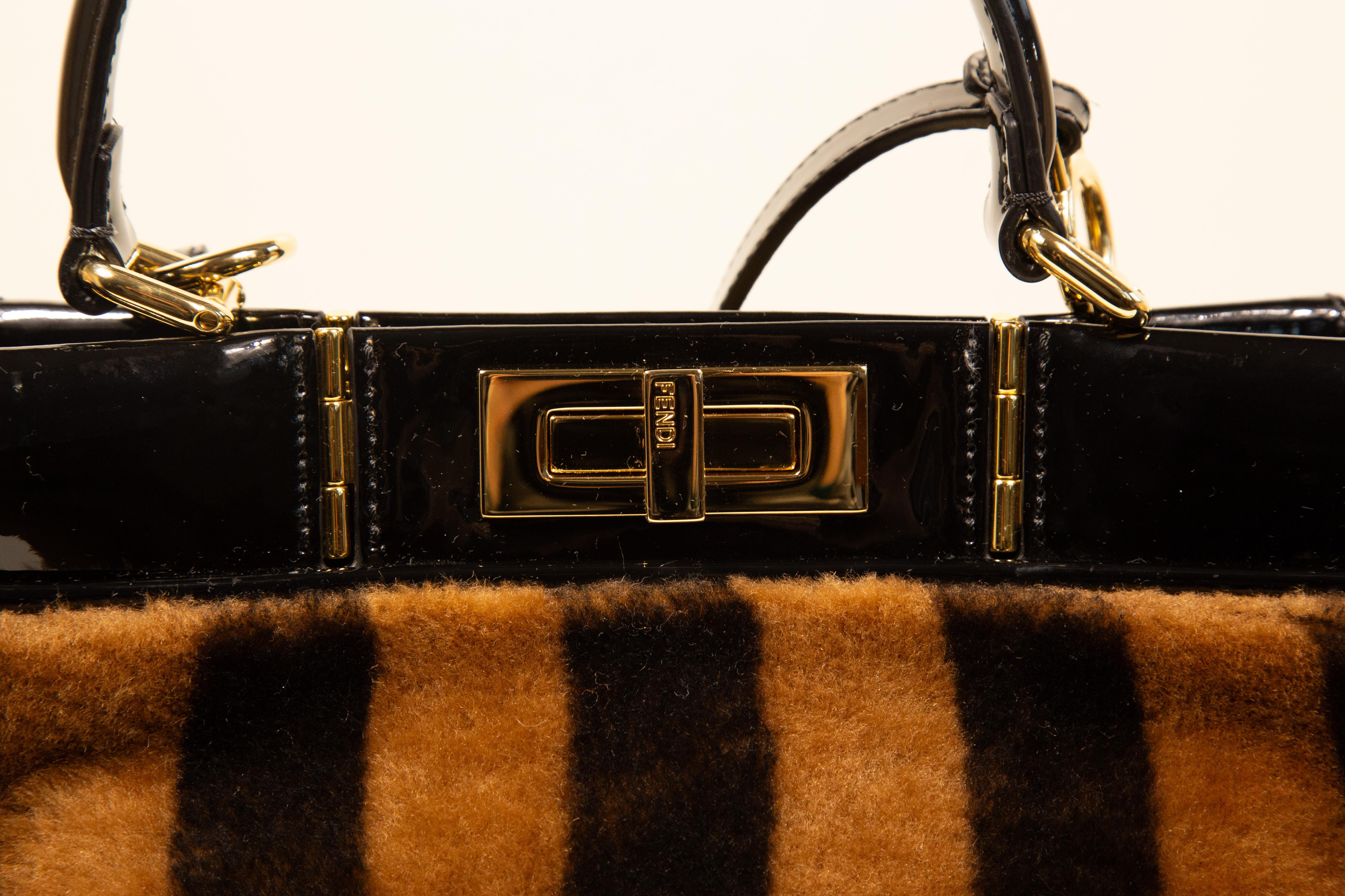 Fendi Peekaboo Shearling Pequin Tobacco Black  2 way bag made of shearling fur, black patent leather and gold toned hardware. The interior is lined with black fabric and black patent leather. It features two compartments and one side pocket with a
