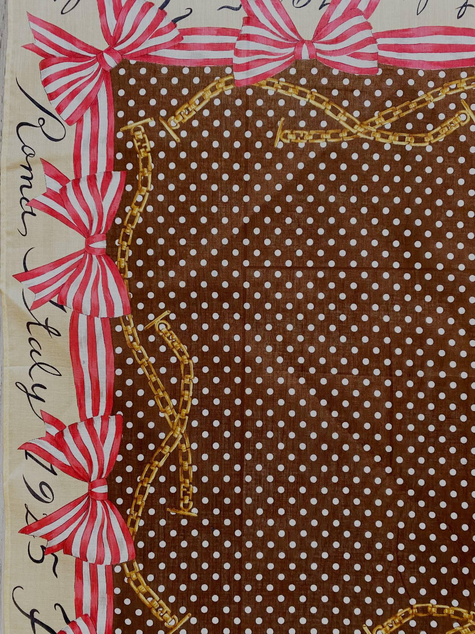 Cette écharpe Fendi Roma des années 2000 est réalisée en coton et présente un motif de nœuds roses sur des pointillés bruns. Fabriquée en Italie.

Dimensions : 32x32cm 

Condition : 2000s, vintage, très bon, avec étiquettes autocollantes 