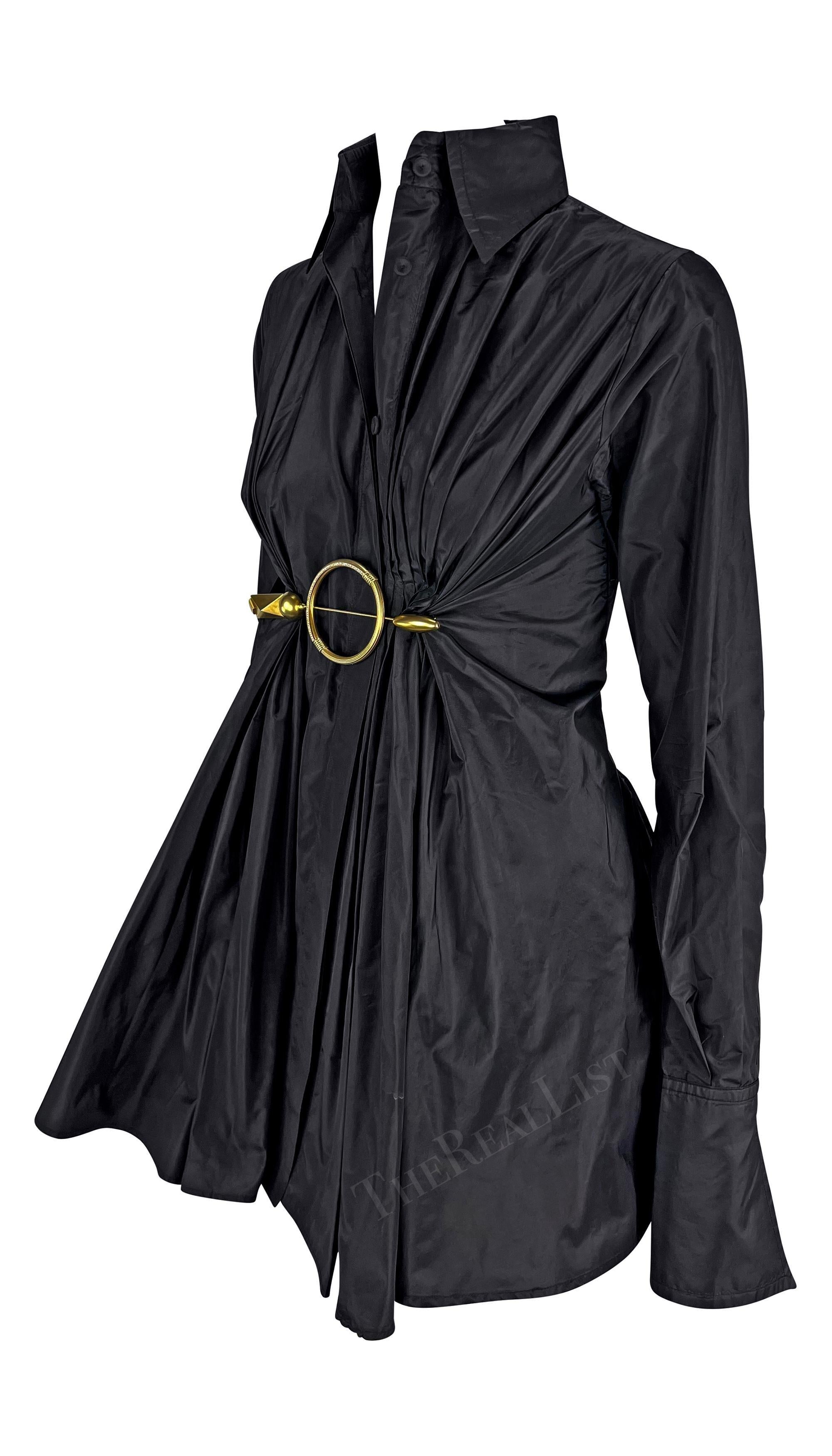 Ti presentiamo uno splendido top con colletto in seta nera di Gianfranco Ferre. Questo top nero, risalente ai primi anni 2000, presenta un collo alto, maniche lunghe a campana e chiusura con bottoni. Il top è impreziosito da un'arricciatura a pieghe
