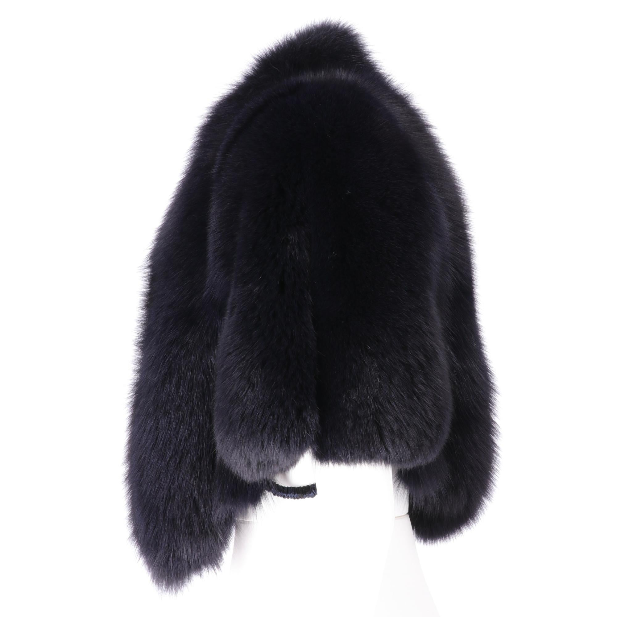 Gianfranco Ferrè real blue fox fur short to the waist cape, with inserts in leather of the same color, padded shoulders, elastic bands and hooks for the arms, lined in silk jacquard fabric, front closure with hook and chain.

This item belongs to an