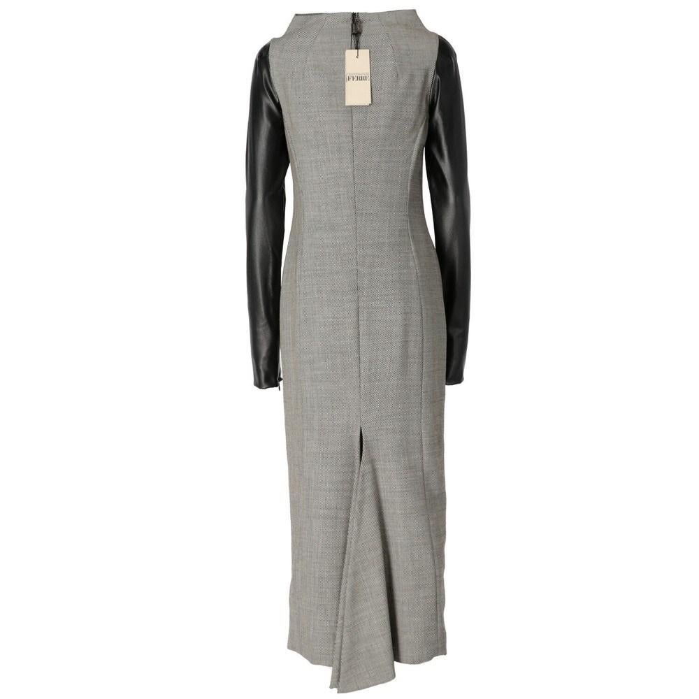 Gianfranco Ferré grey and white wool long dress with faux leather's sleeves. Rear back zip fastening and deep slit.

Size: 42 IT

Flat measurements
Height: 132 cm
Bust: 41 cm
Shoulders:46 cm
Sleeves: 68 cm
Waist: 37cm

Composition: 97% Virgin wool -