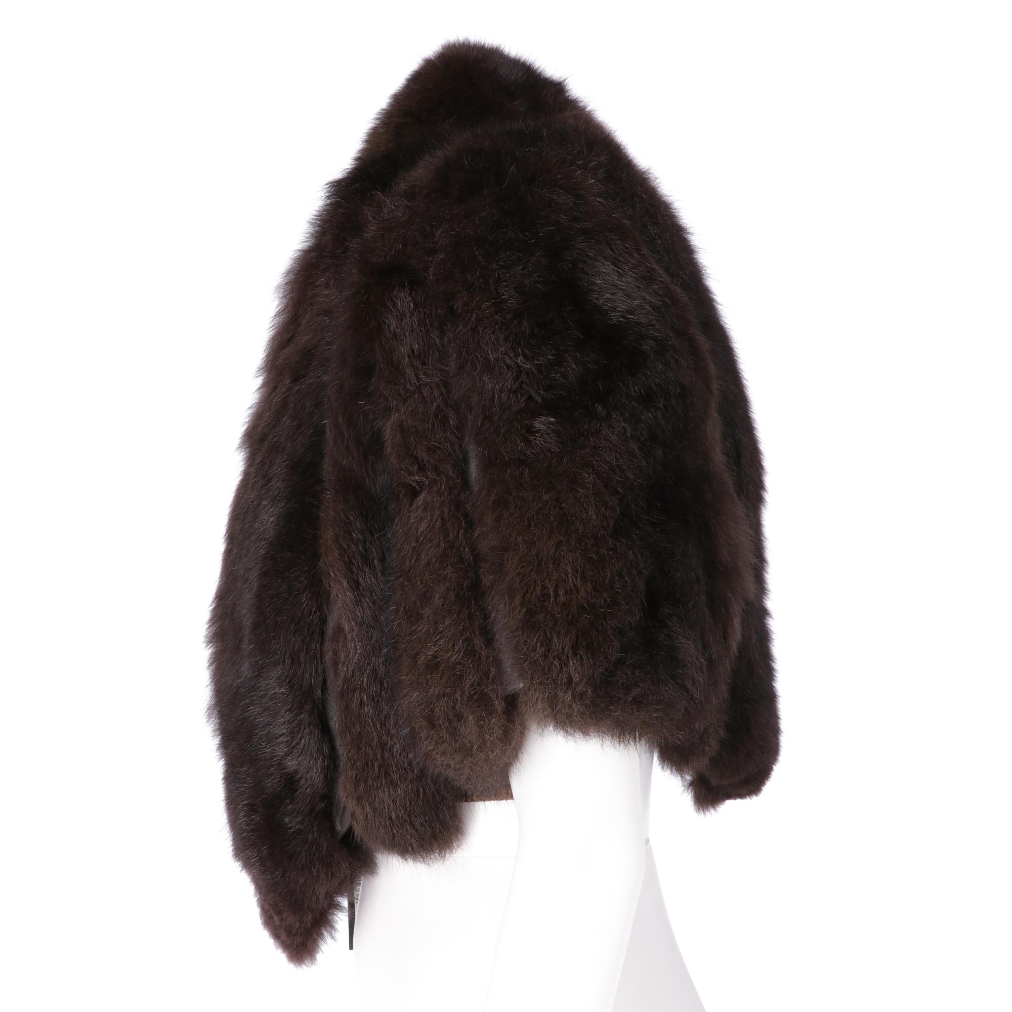 Gianfranco Ferrè real brown opossum fur short to the waist cape, with leather inserts of the same color, padded shoulders, elastic bands and hooks for the arms, lined in silk jacquard fabric, front closure with hook and chain.

This item belongs to