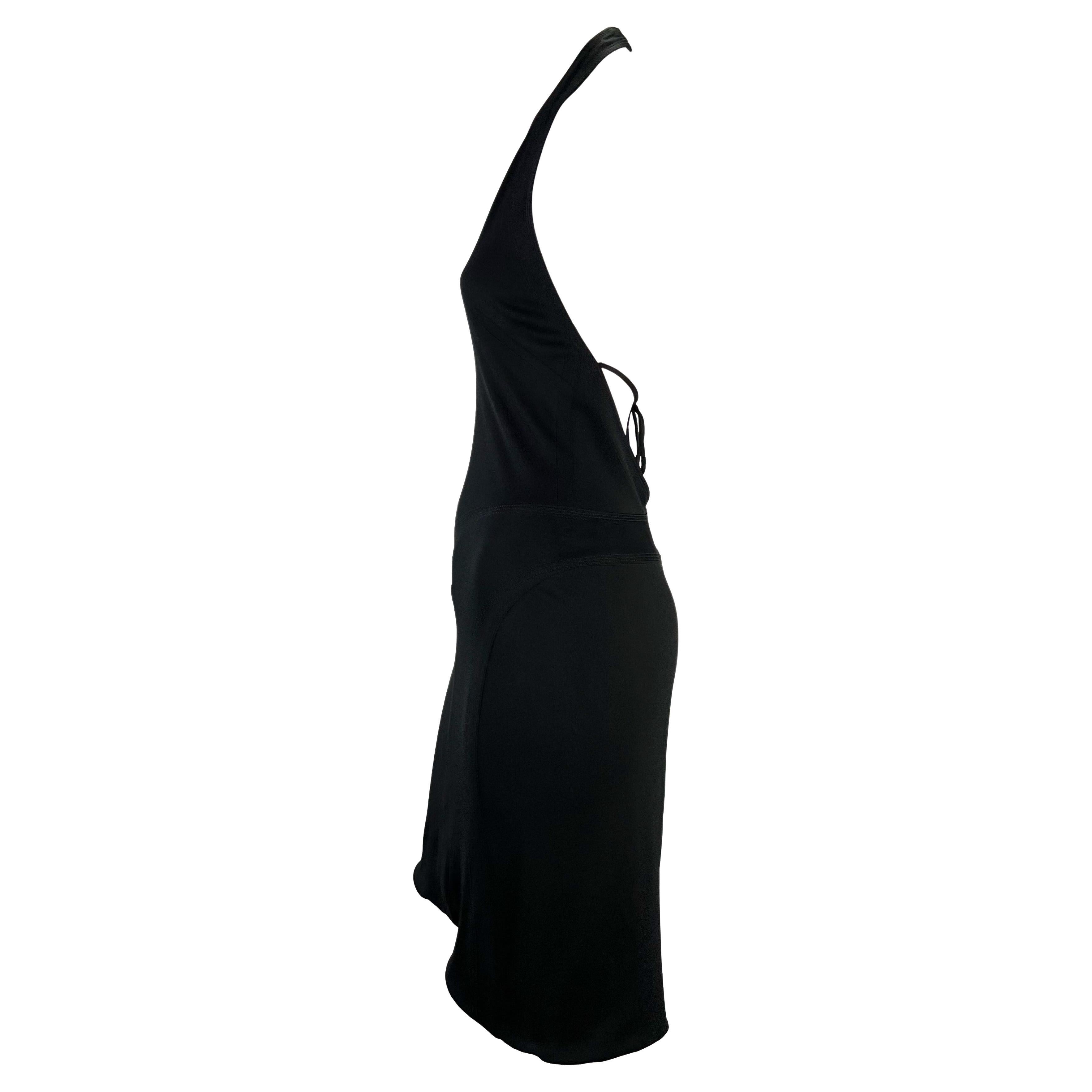 Présentation d'une robe dos nu en stretch noir Gianni Versace, dessinée par Donatella Versace. Datant du début des années 2000, cette robe fabuleuse et coquette présente un décolleté en V plongeant, un dos découvert avec un lien autour de la taille