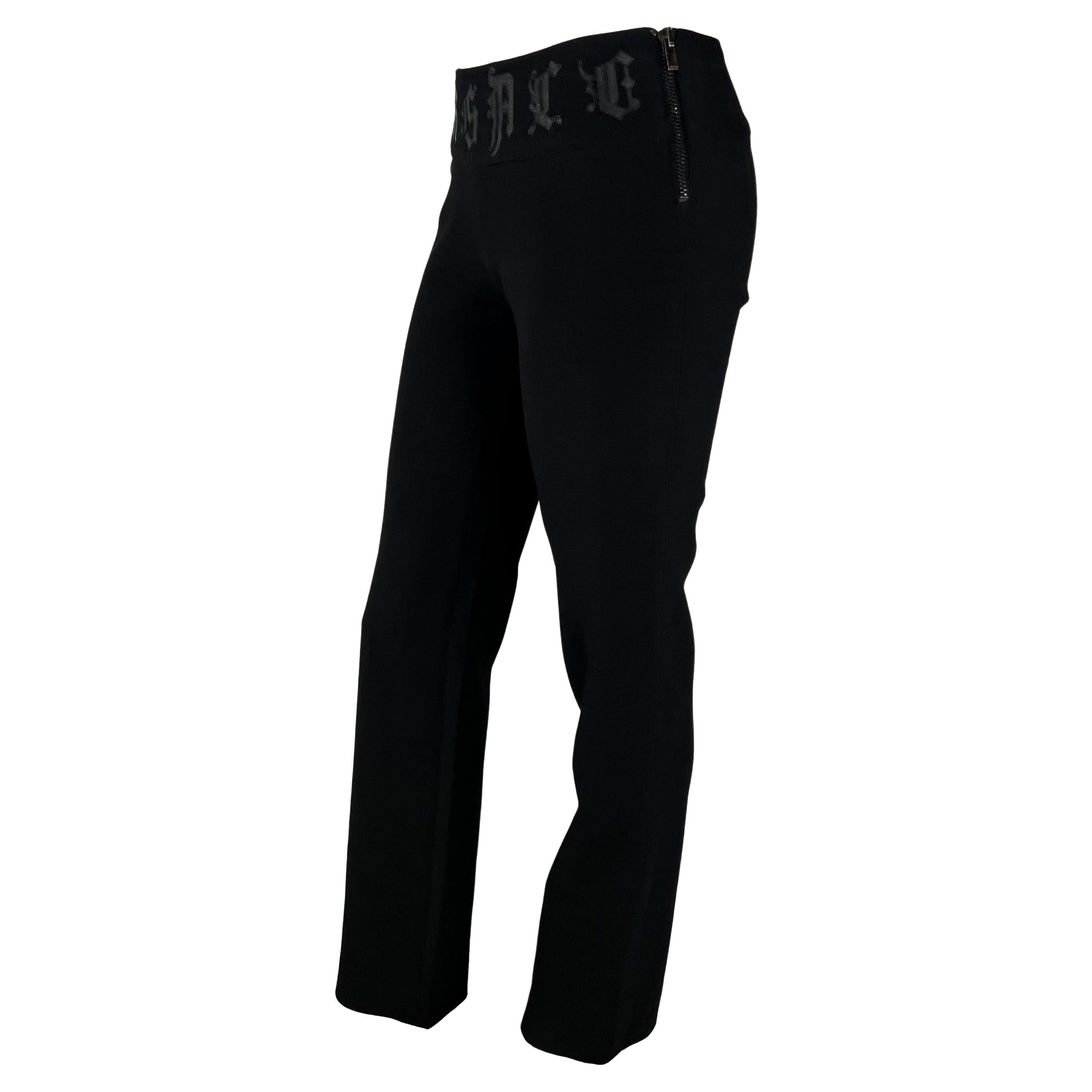 Presenting a fabulous black pair of Gianni Versace spell-out pants, designed by Donatella Versace. From the early 2000s, these wool pants feature 'Versace' spelled out on the front in leather appliqués. The pants are made complete with a zipper