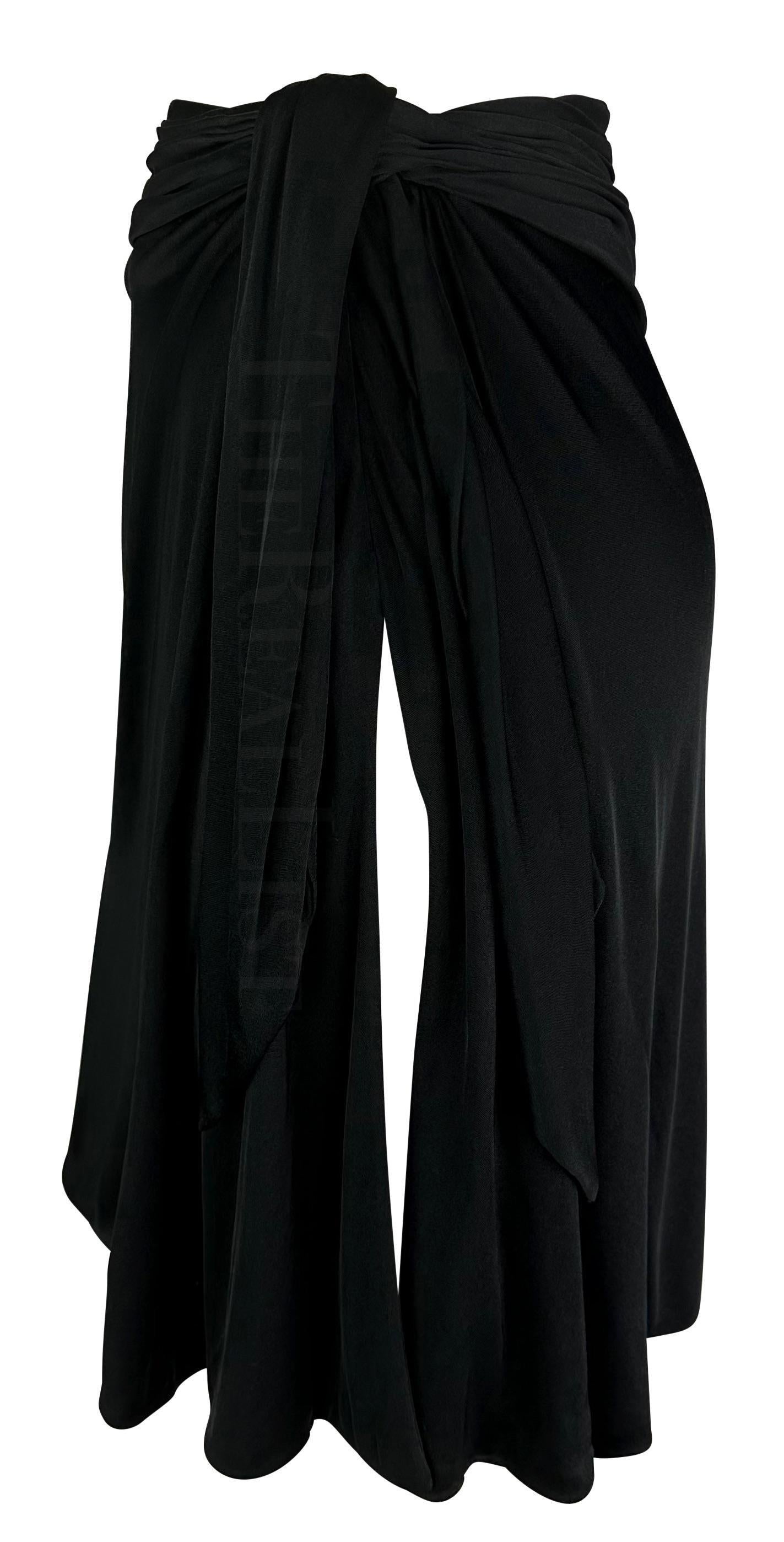 Presenting a fabulous black Gianni Versace wrap-style skirt, designed by Donatella Versace. From the early 2000s, the asymmetric wrap design cinches elegantly with a 'tie' closure, while a daring side slit creates an enticing edge to this sexy