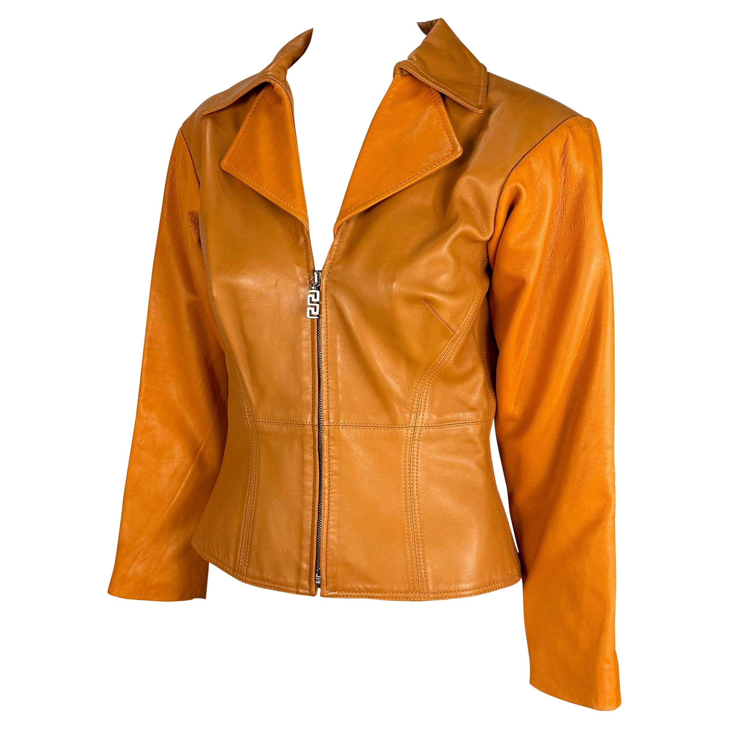 Wir präsentieren eine wunderschöne orangefarbene Lederjacke von Gianni Versace Couture, entworfen von Donatella Versace. Dieses einzigartige Stück hat einen Kragen, einen tiefen Ausschnitt und einen halben Reißverschluss. Diese von Donatella Versace