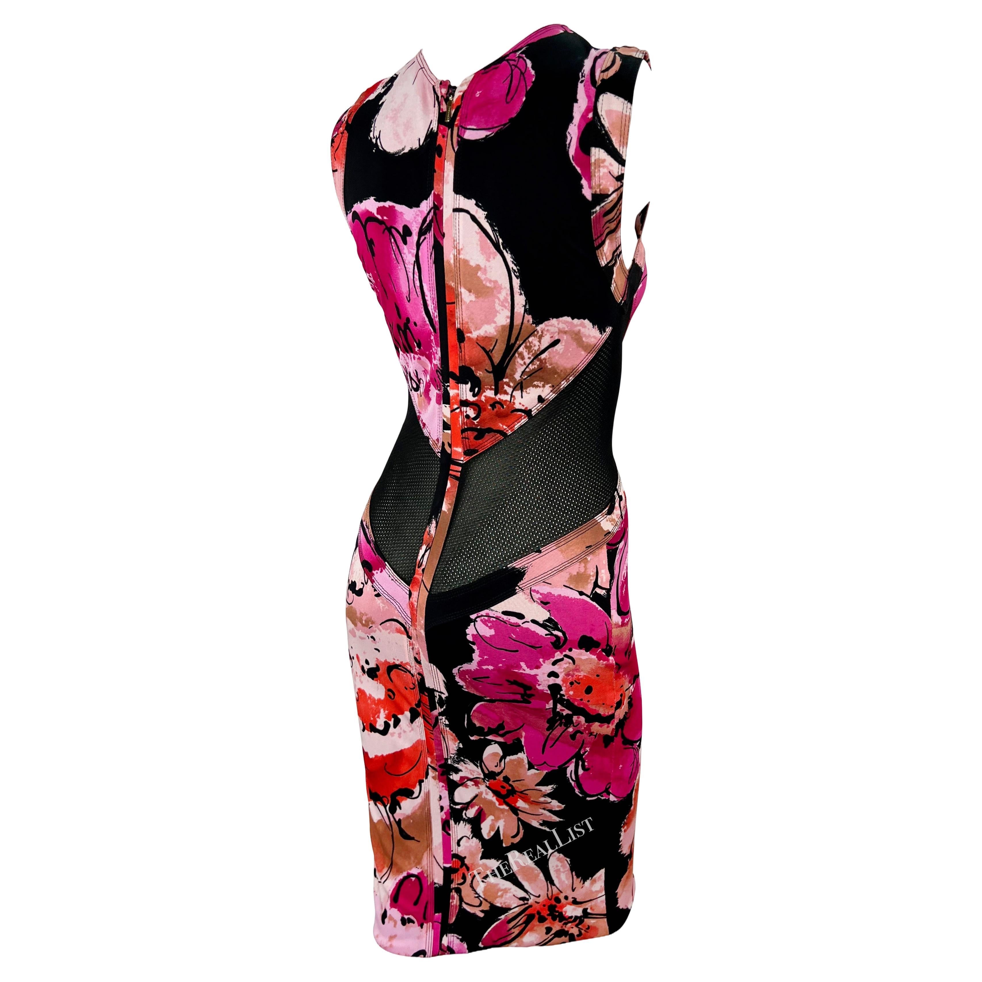 A chic pink floral mini dress by Donatella Versace for Gianni Versace from the early 2000s. This stretchy, form-fitting dress showcases a bold abstract floral print.The sleeveless dress features a crew neckline and is made complete with two black