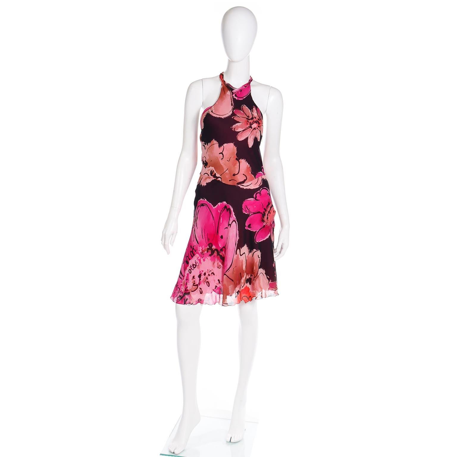 This vintage floral tissue silk Gianni Versace dress was designed by Donatella Versace in the early 2000's, The dress is cut on the bias and has high slit flyaway panels and lettuce edging. The fabric is a luxe sheer black silk crepe with bold pink