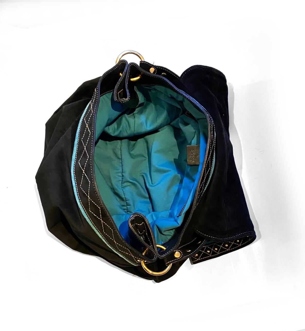 2000s Gucci Large Shoulder Hobo Bag in navy blue suede, flap closure, multiple Gucci Stemma in gold tone metal at the front lap, stud details, crisscross stitching details, gold tone hardware, navy blue lining, inside pocket, shoulder strap with