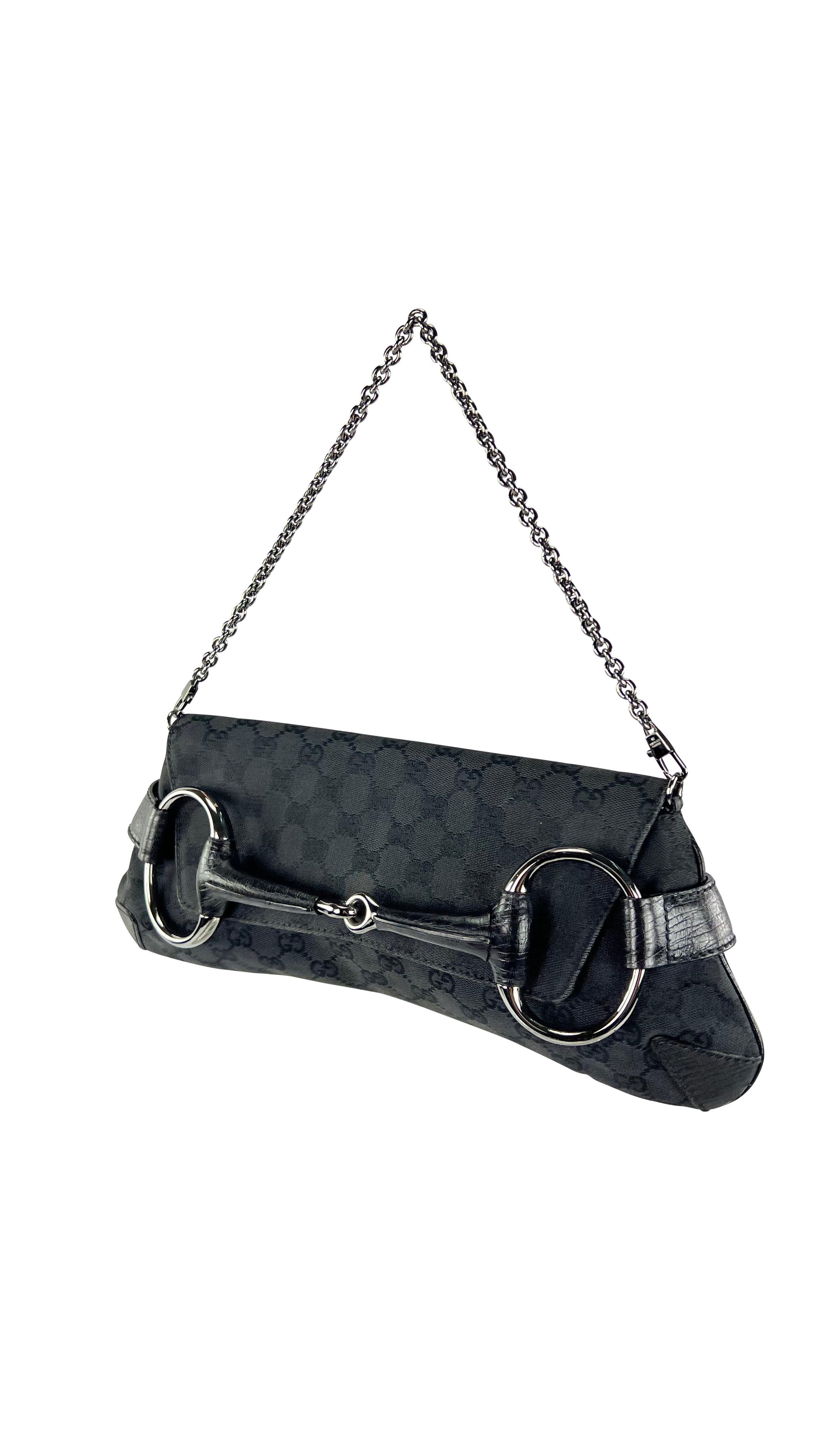 TheRealList presents: a fabulous black canvas 'GG' Gucci horse bit convertible clutch, designed by Tom Ford. From the early 2000s, the bag's horse bit-style silhouette, expertly crafted from exquisite leather, is adorned with a flap, silver chain,