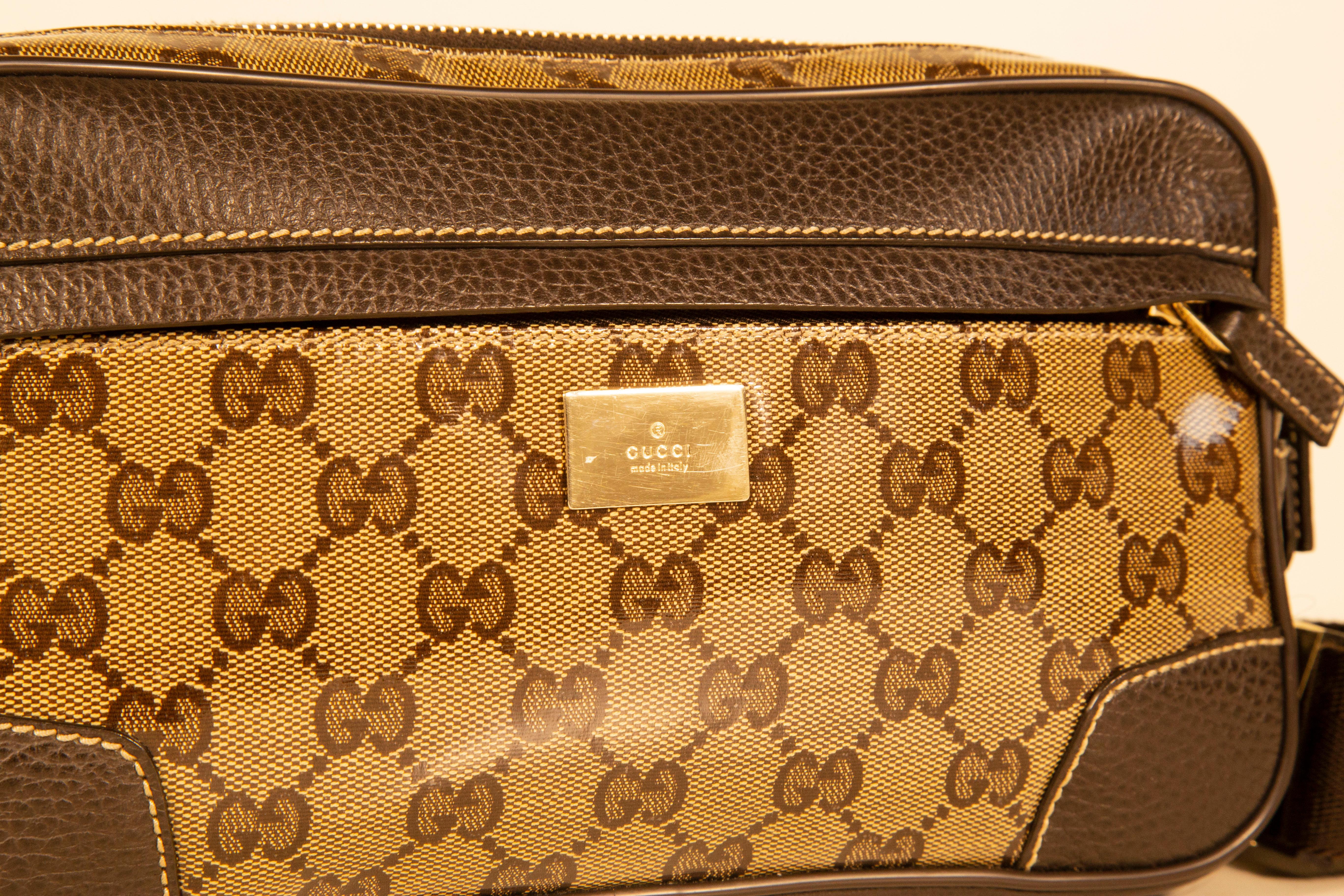 Una borsa da cintura Gucci in tela con cristalli GG marrone/beige, hardware argentato e finiture in pelle marrone. Il cinturino è in tela marrone. La borsa presenta una tasca frontale e lo scomparto principale foderato in tessuto marrone. L'interno