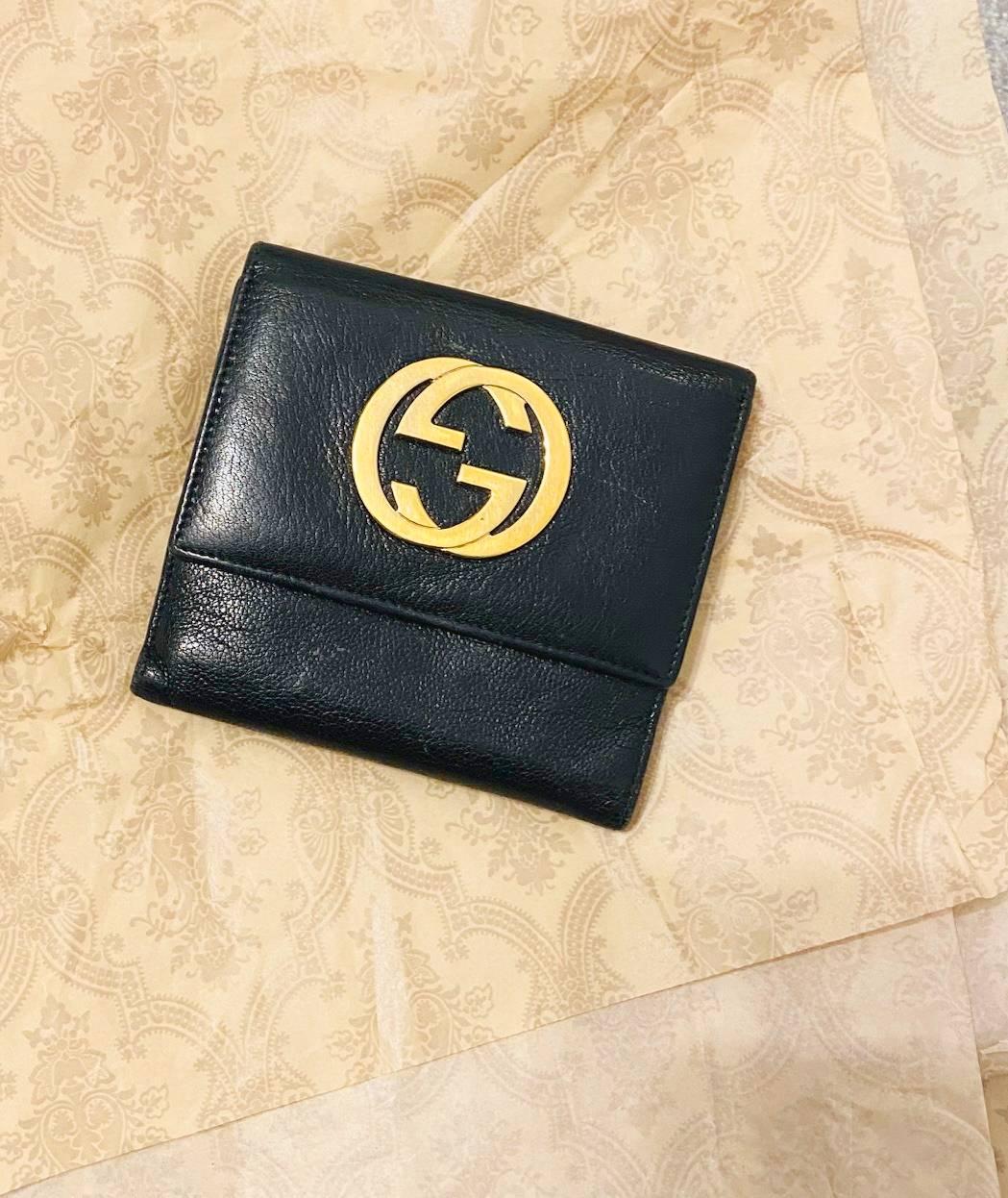 Gucci Tri-Folded Leather Wallet, coin and banknotes compartments, gold front interlocking logo, black leather, Made in Italy 

Dimensions: 12.5x12.5x3.5cm / 4.9x4.9x1.3in 

Conditions: 2000s, vintage, good, minimal wear 