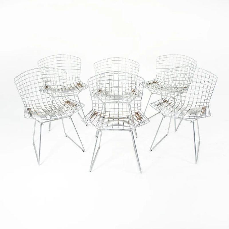 These are classic Bertoia side chairs, model 420c, designed in 1952 by Harry Bertoia for Knoll International. These chairs consist of welded chromed-steel wire seats & backs, and retain their original blue seat pads. These date to circa mid 2000s