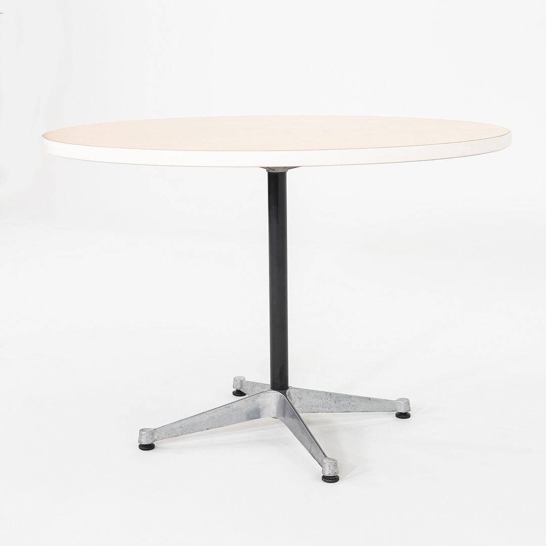 This is an Occasional Table, originally designed by Ray and Charles Eames in 1958. This particular example was produced by Herman Miller in the USA in the 2000s. The table is comprised of an aluminum base with a wood laminate tabletop. 

The table