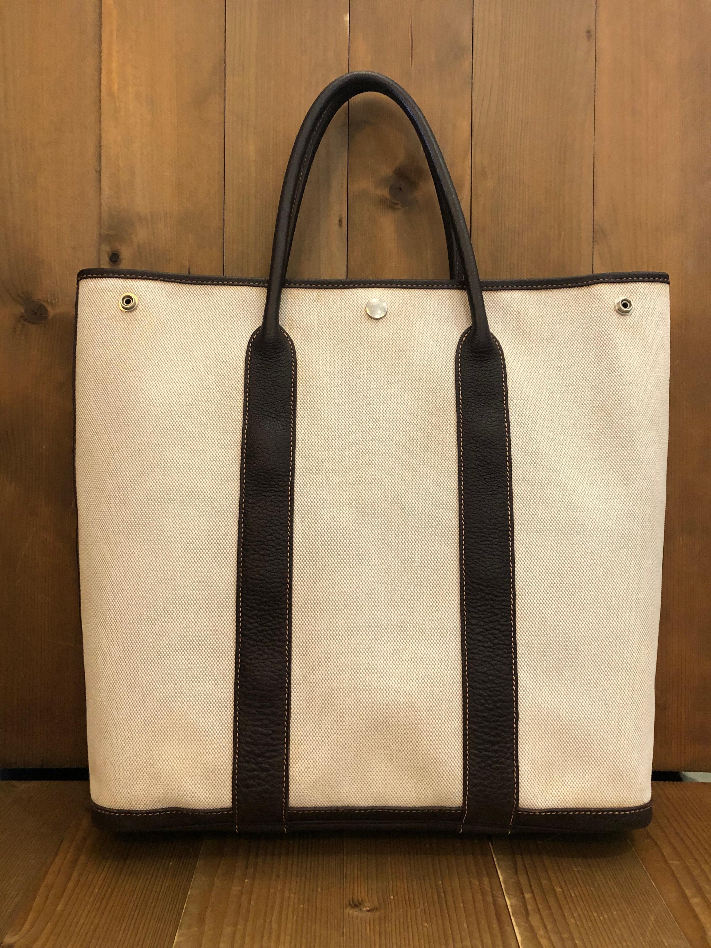 2000s Hermes Garden Party vertical tote bag in natural ivory linen and brown Ebene buffalo leather. Stamped square H (2004). Made in France. Snap fastening closure. Measures approximately 17 (top) 14 (bottom) x 14.5 x 3.5 inches.

Condition - Minor