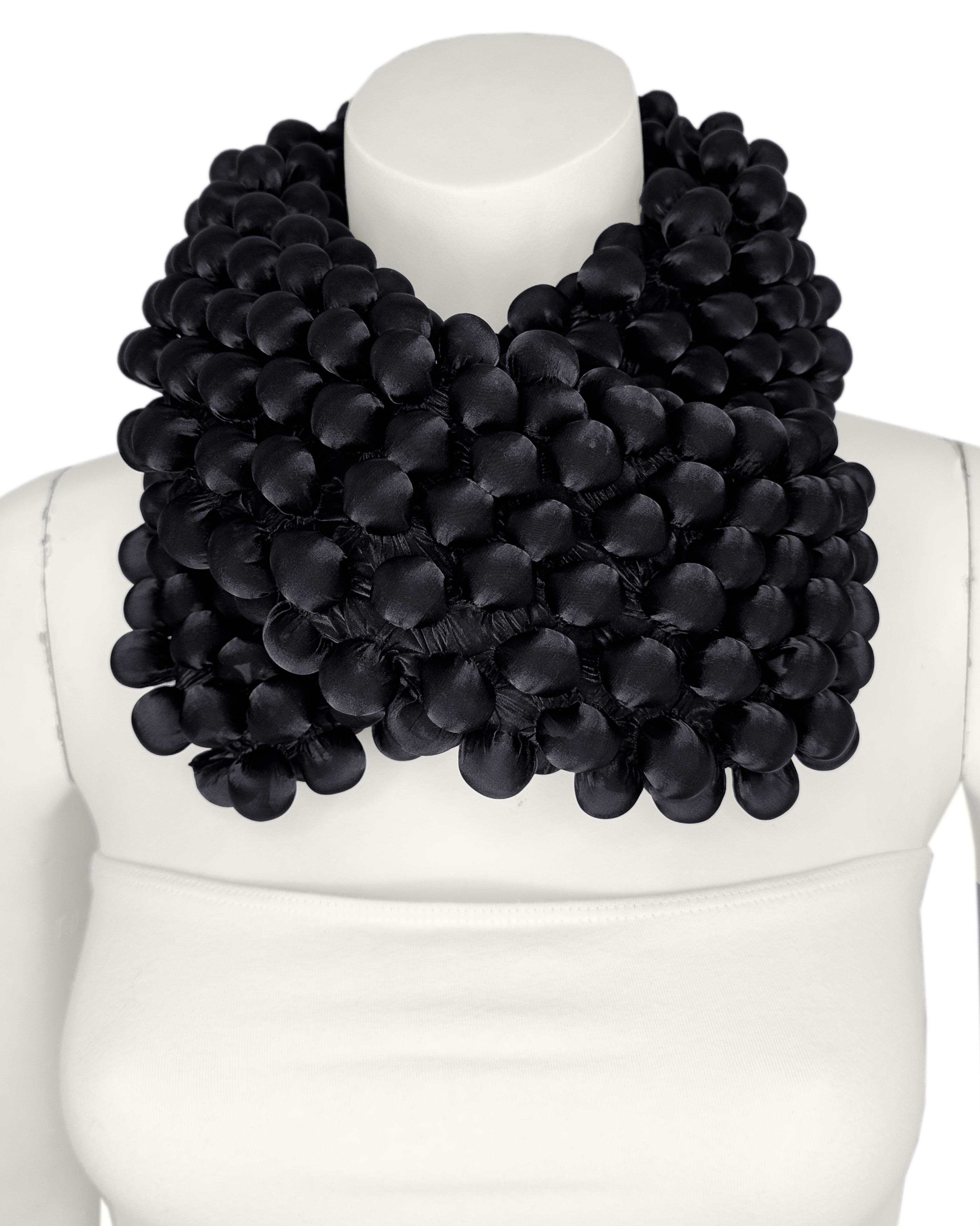Issey Miyake black bubble wrap scarf. Has 2 crinkle ribbon ties at either end. Rectangular shaped. In excellent condition. The fabric is very stretchy 100% polyester, measurements are taken flat.

Length 35