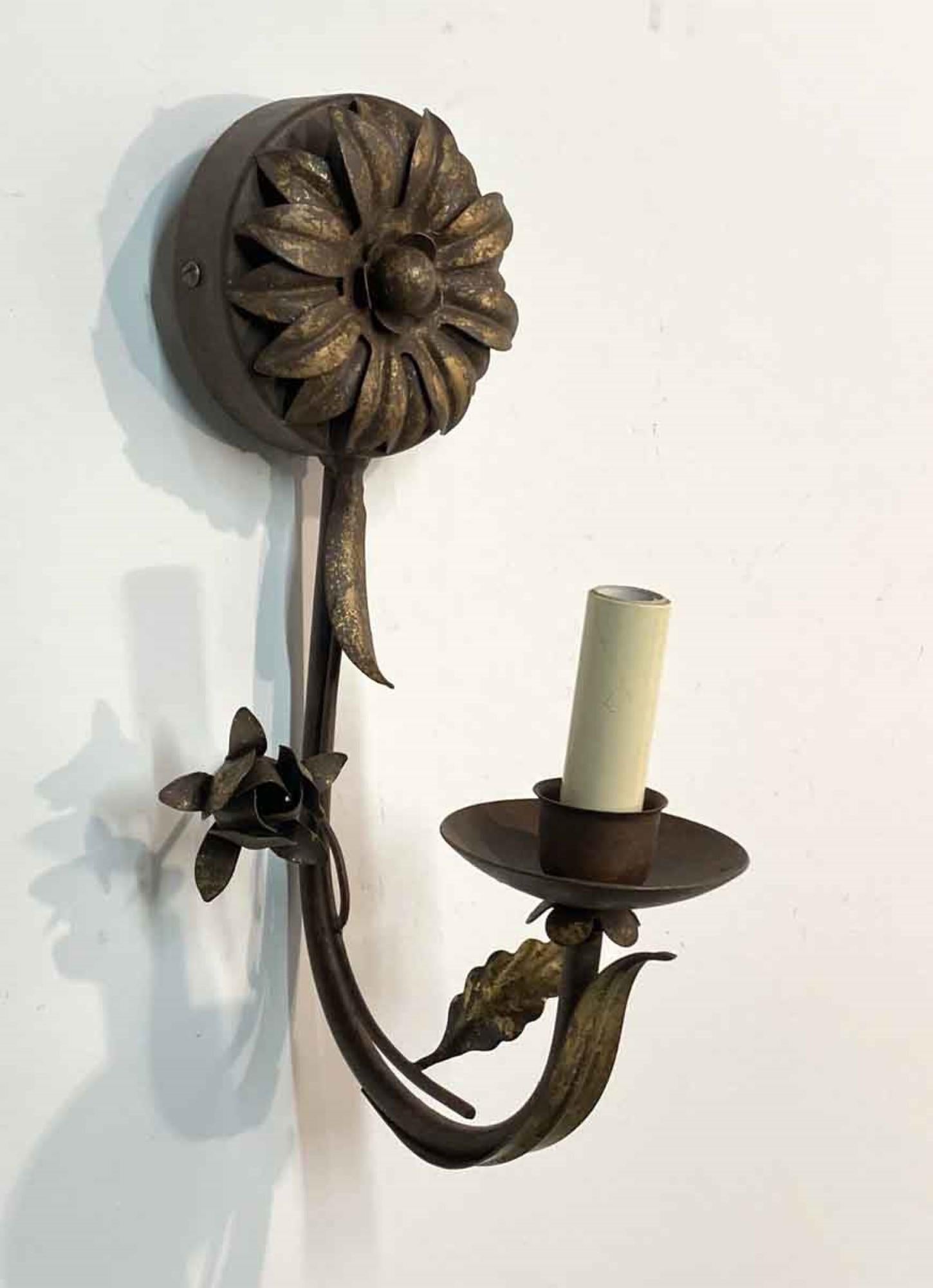 2000s Italian Florentine sunflower style wall sconce. Hand wrought iron with a single arm. Done in a brown tone and gold gilt finish. This light takes one 60 W candelabra bulb. Small quantity available at time of posting. Priced each. This can be