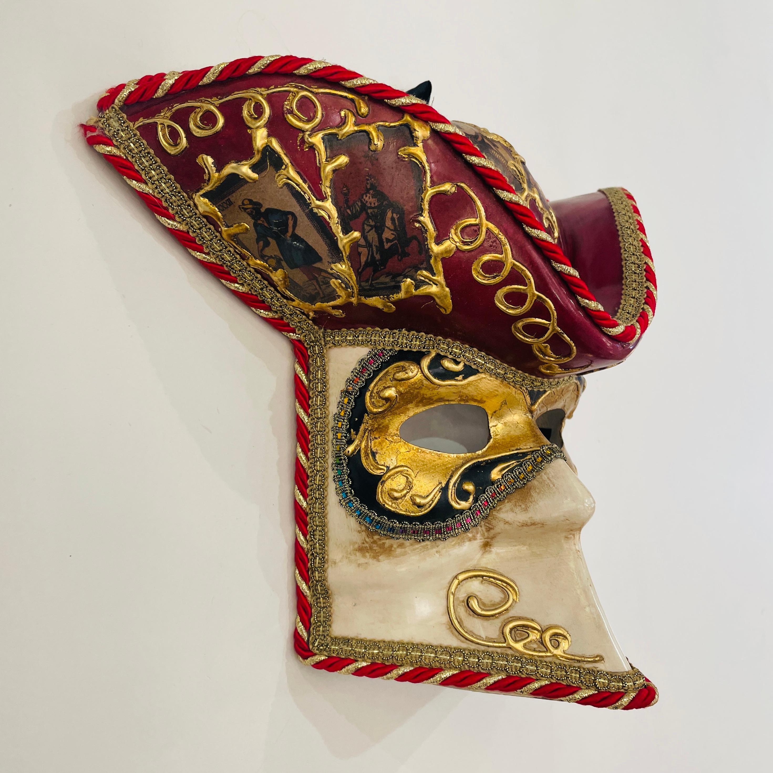 Diese Narrenmaske der Volkskunst ist eine echte venezianische Kreation, die im Jahr 2000 vollständig von Hand gezeichnet und angefertigt wurde. Italienische Künstler haben dieses Stück in voller Achtung der handwerklichen Traditionen und in