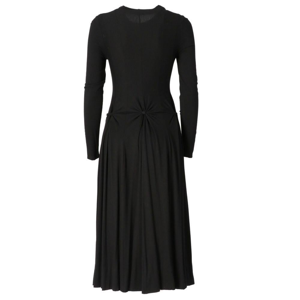 Jil Sander black stretch fabric dress. Round neck model, decorative knots at the waist, long sleeves and uncle on the neck.

Size: 38 IT 

Flat measurements
Height: 118 cm
Bust: 38 cm 
Shoulders: 36 cm
Sleeves: 60 cm

Composition: