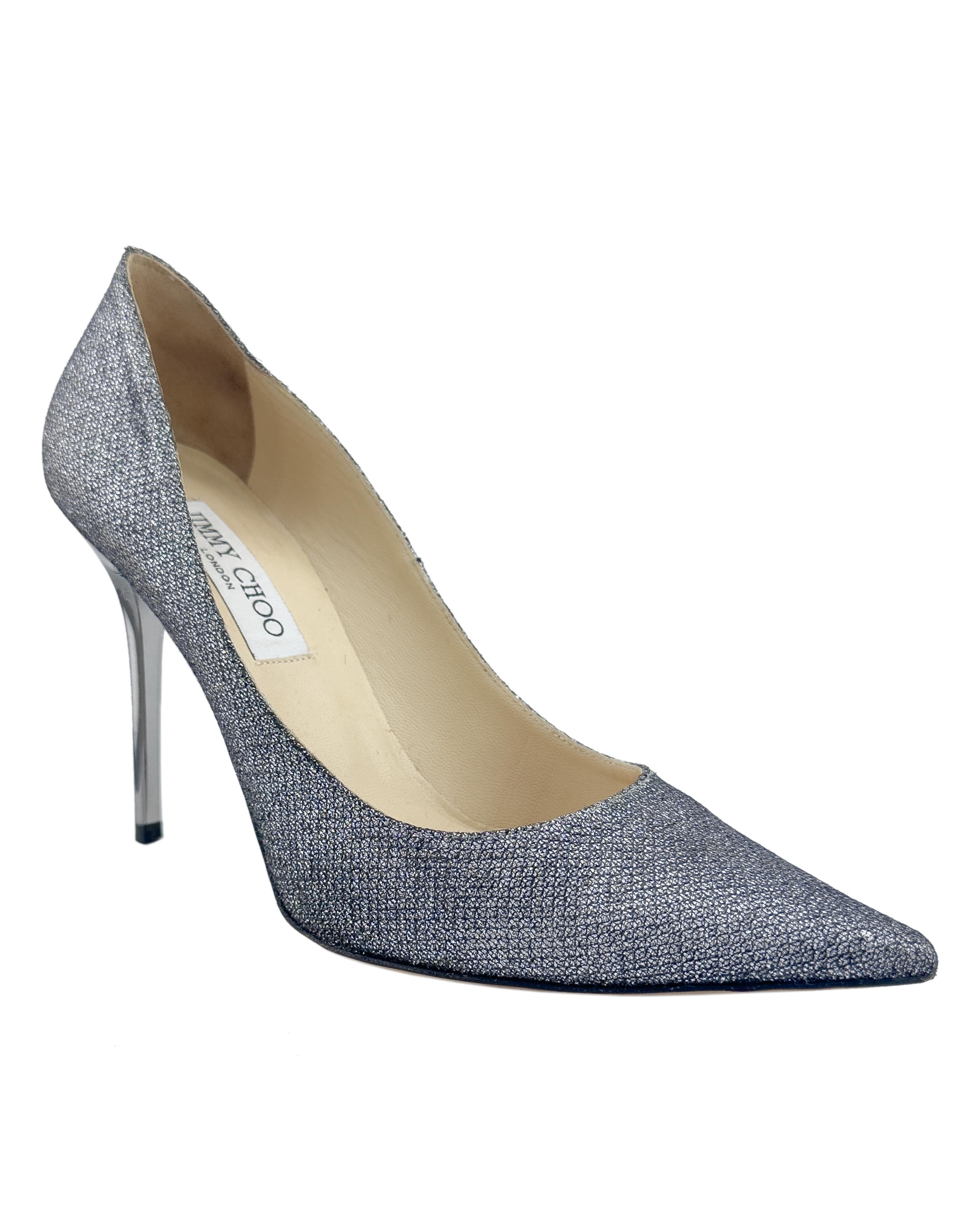 Pompa Agnes di Jimmy Choo della fine degli anni 2000 in lurex grigio canna di fucile. La classica silhouette a punta è rivisitata in un tessuto glitterato che cattura la luce a ogni movimento. Con un elegante tacco a spillo grigio da 85 mm, la