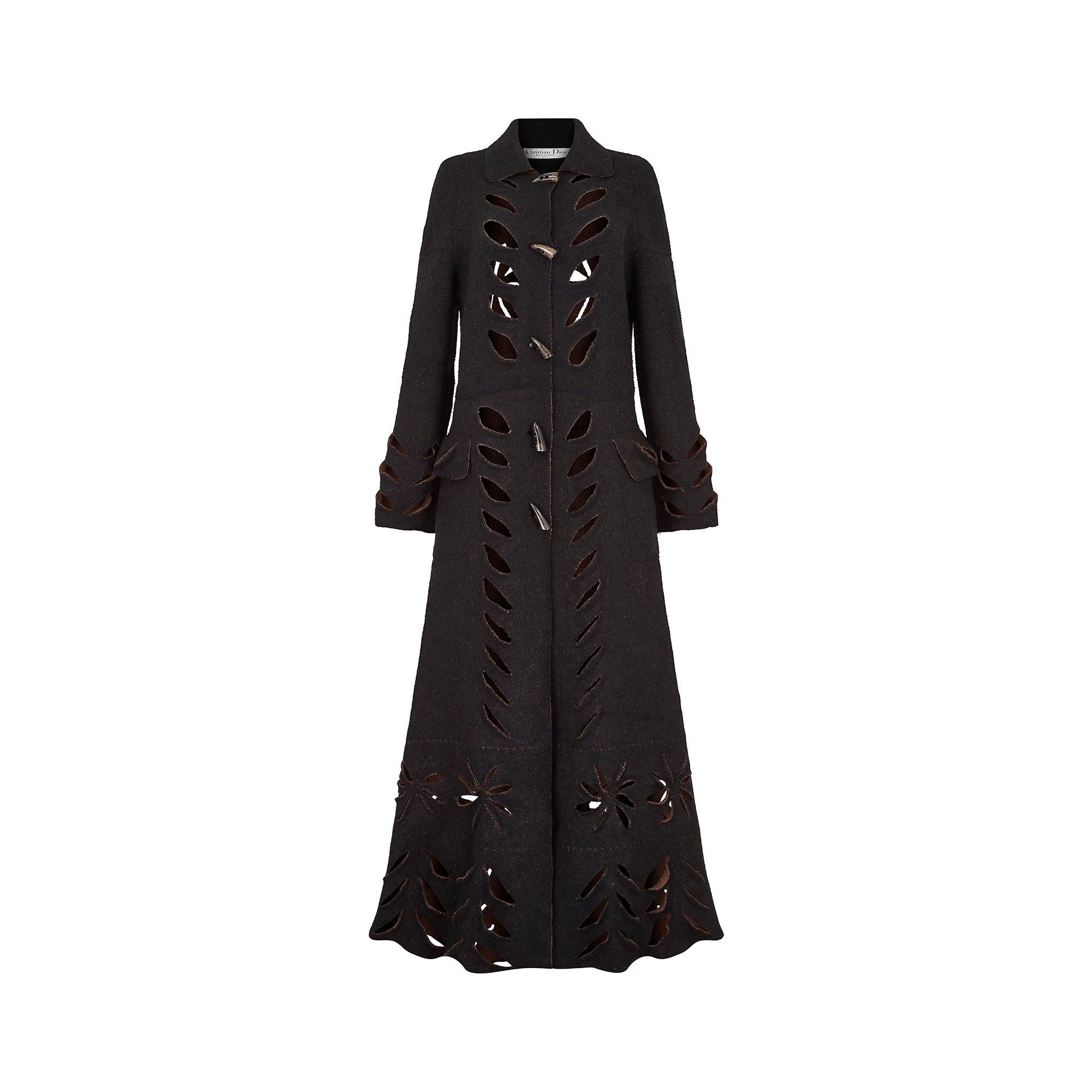 This John Galliano for Christian Dior wool felt coat is in a classic late 1990s or Y2K 'coatigan' shape, with wide sleeves and button detail.  It features an unusual cutout design of flowers and slits which create an almost leaf-like shape. The