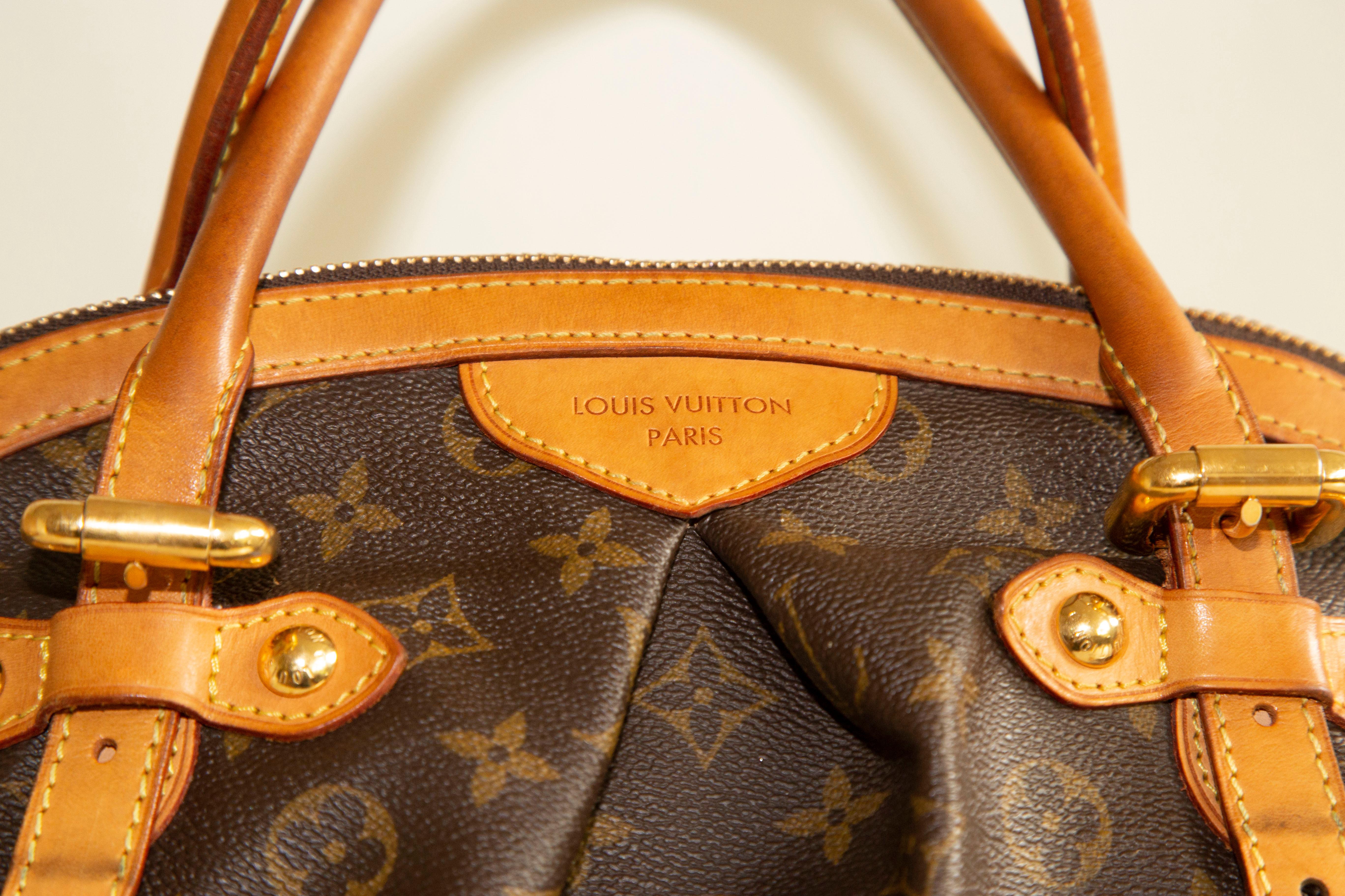 A Louis Vuitton Tivoli GM handbag/shoulder bag. The bag is made of brown coated canvas with the signature monogram. It features a tan leather trim, and gold toned hardware. The interior is lined with brown fabric and next to the major compartment it