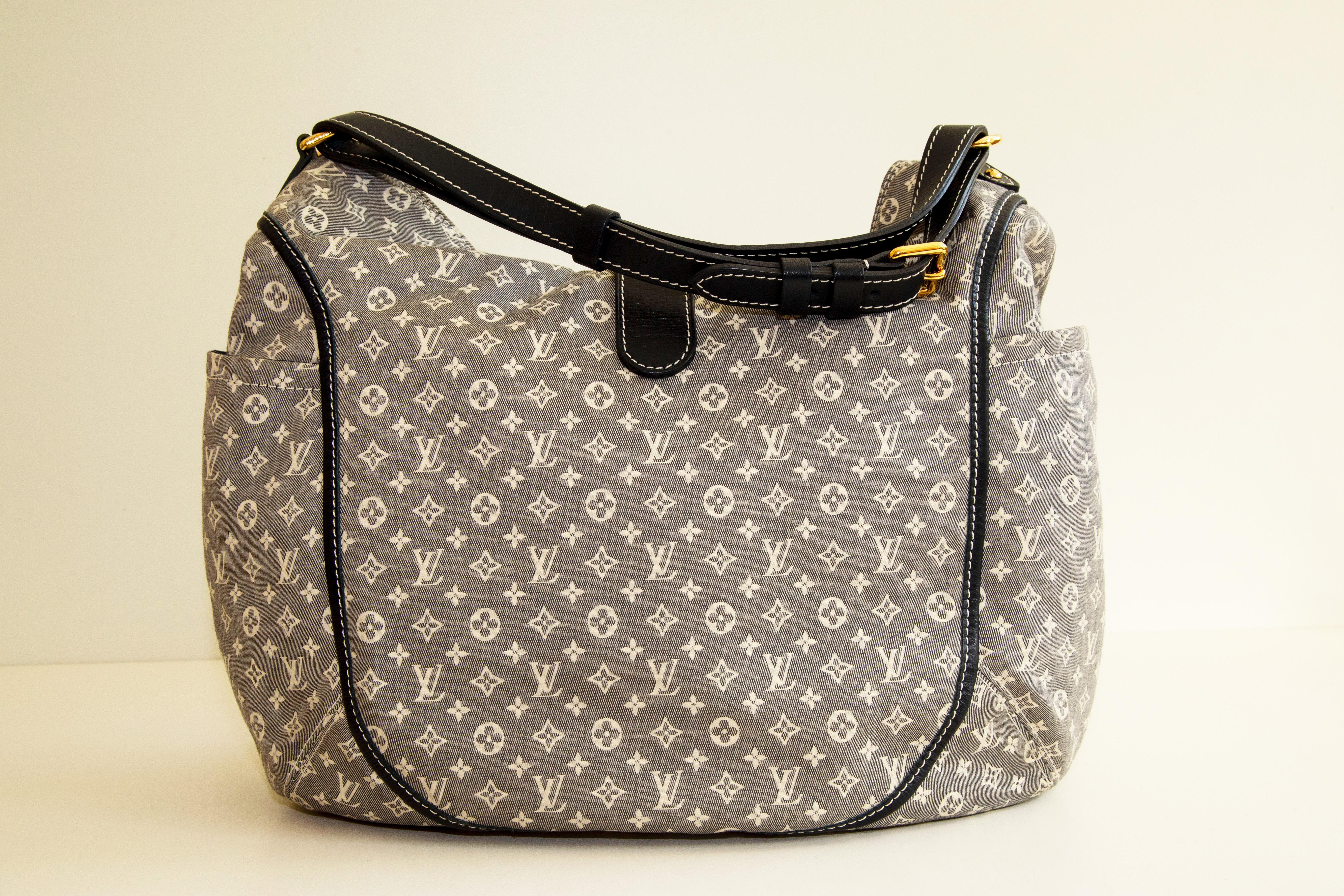 Un authentique  Sac à bandoulière Louis Vuitton Idylle Romance. Le sac se compose de deux poches latérales et d'un compartiment principal. Le compartiment principal comporte deux poches latérales et est doublé d'un tissu bleu foncé. Le matériel