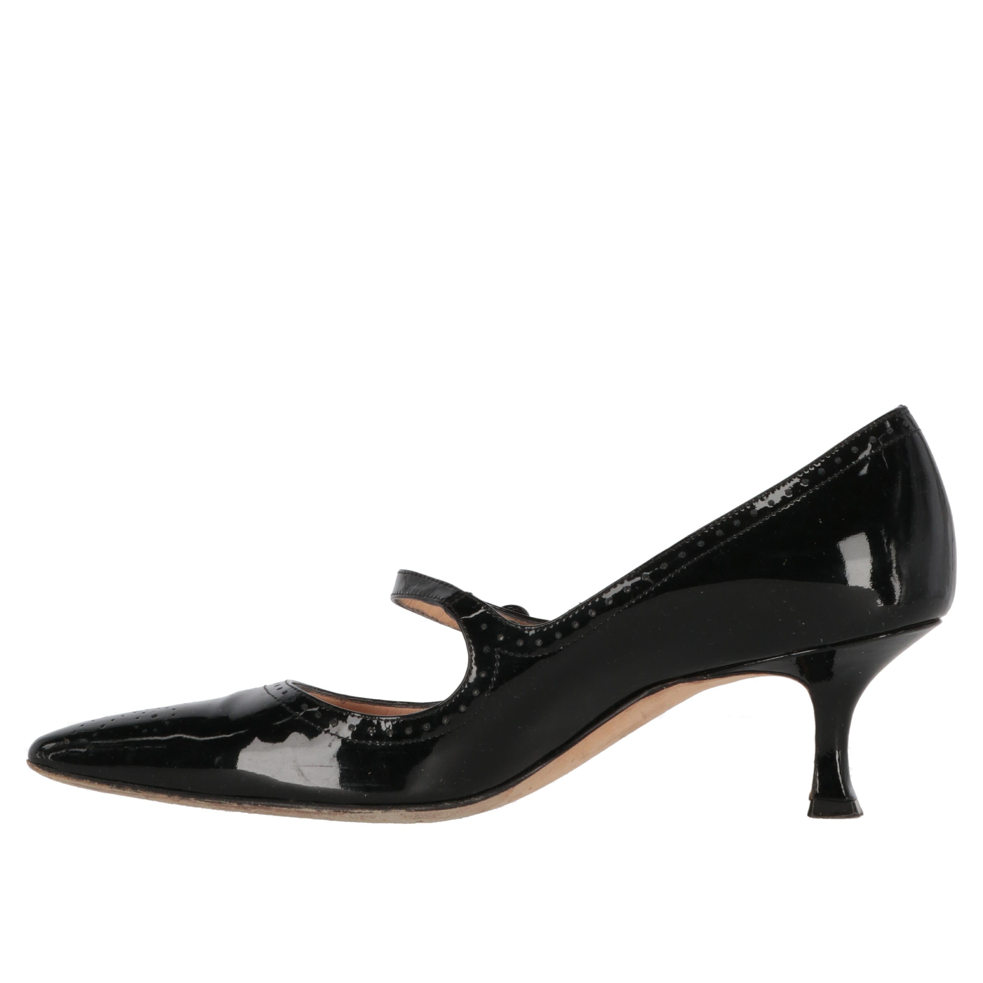 Manolo Blahnik black patent leather Mary Jane shoes with low heel, perforated details and strap with elastic button.

There are some slight signs of wear on the tip and creases from use, as shown in the pictures.

Years: 2000s

Hand made in
