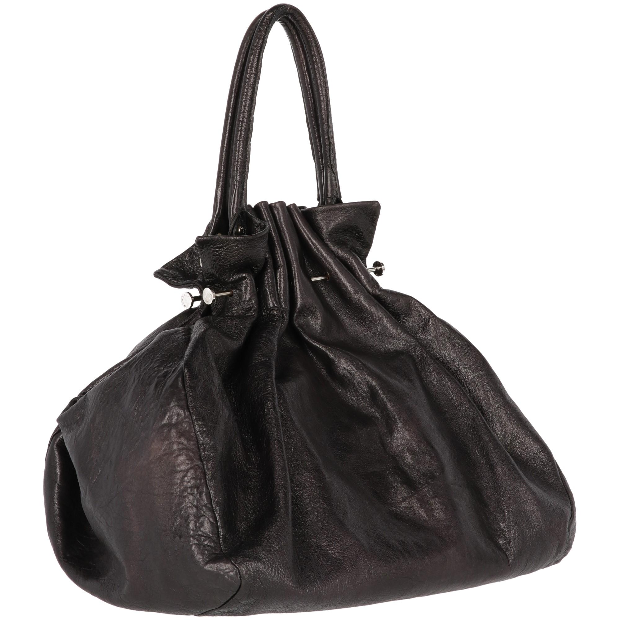 The stylish Marni black leather tote bag features decorative curliness details on both sides and silver-tone metal decorative details. With removable handles and inner pockets, the bag shows lightly fading signs at leather, as shown in the
