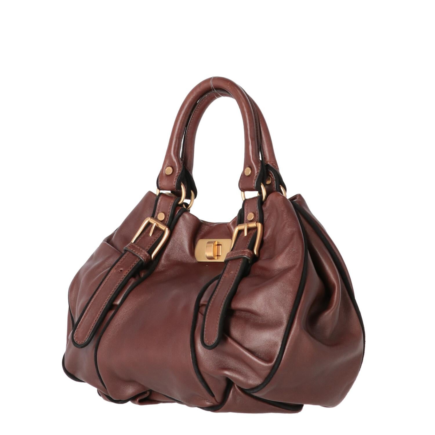 A.N.G.E.L.O. Vintage - ITALY
Marni brown leather handbag with black finished edges. Draped design, golden metal details and front hook closure.

The bag shows light signs of wear on the leather and on the metallic parts as shown in the
