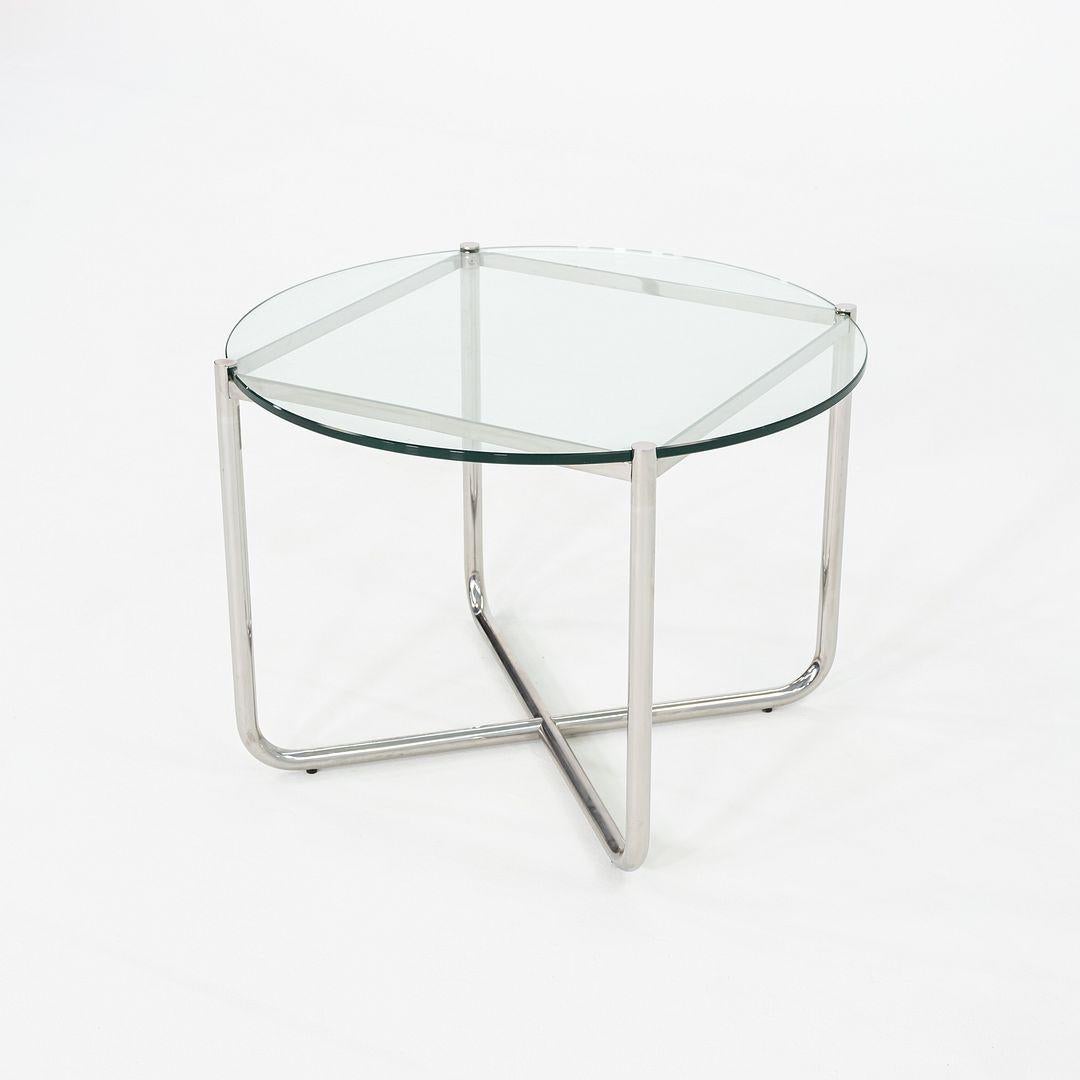 This is a MR End Table, originally designed by Mies van der Rohe for Knoll in 1927. This particular example was produced in the 2000s. The table features a round glass top supported by a chromed tubular steel base, which is formed into an