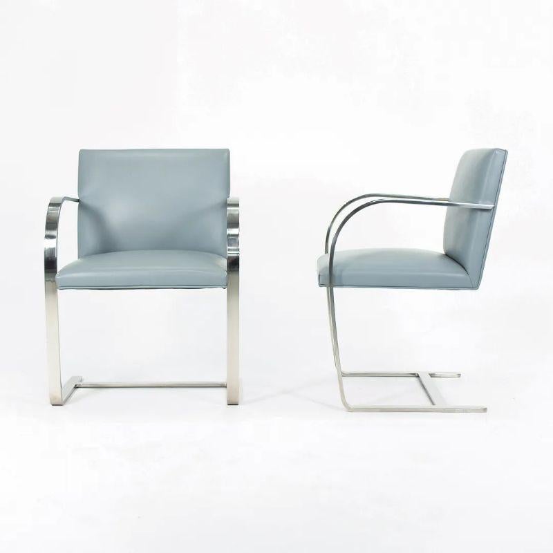 This is the Flat Bar Brno Chair (five are available, priced separately), designed by Mies van der Rohe and manufactured by Knoll. Notably, this is the solid stainless steel version with gray/blue leather upholstery. The stainless examples are sought