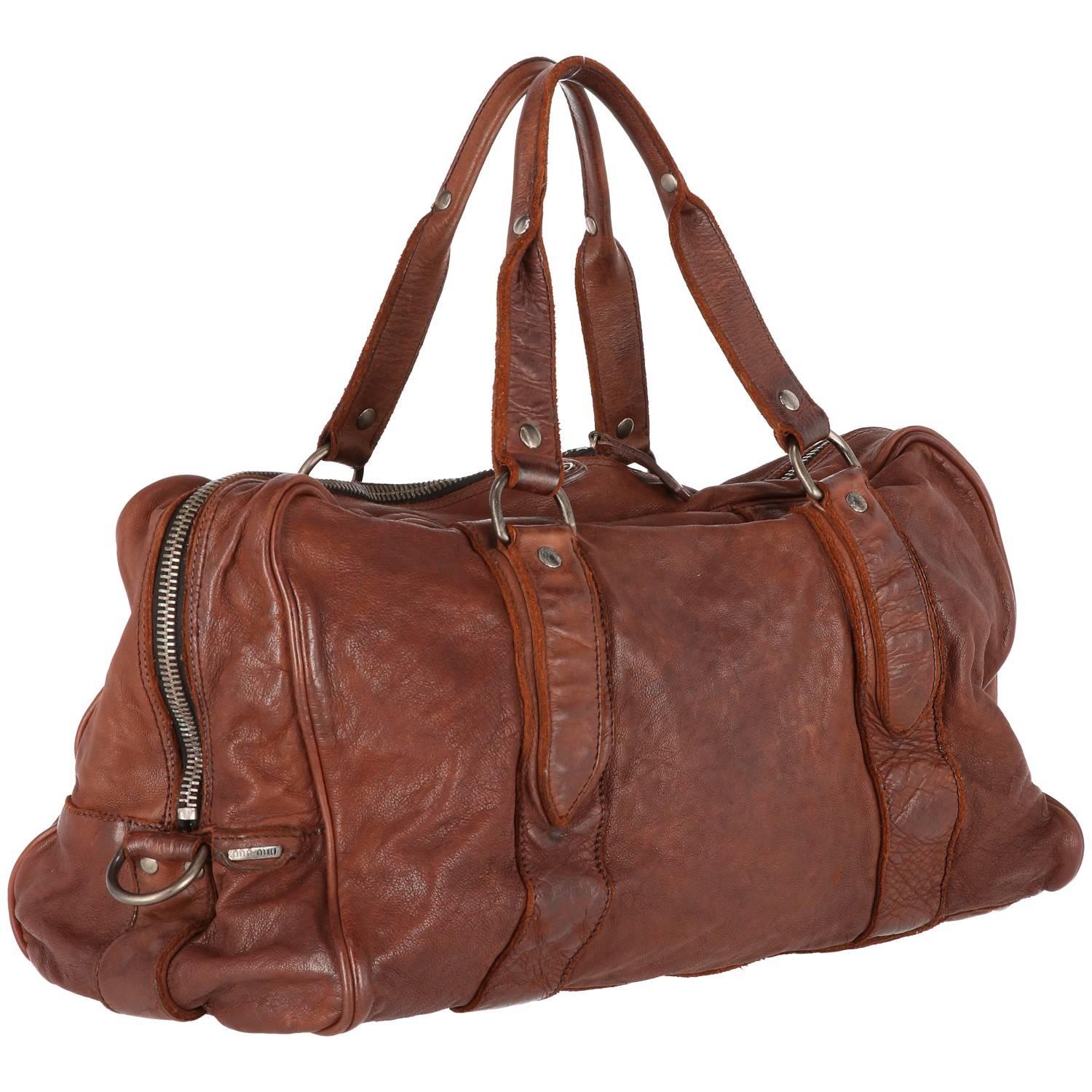 Miu Miu travel bag in voluptuous brown leather from the 2000s. Features a double zip fastening and an inside lining with zipped side pocket. The leather has a beautiful vintage aged finish.
Excellent conditions.

Handle Width: 20 cm